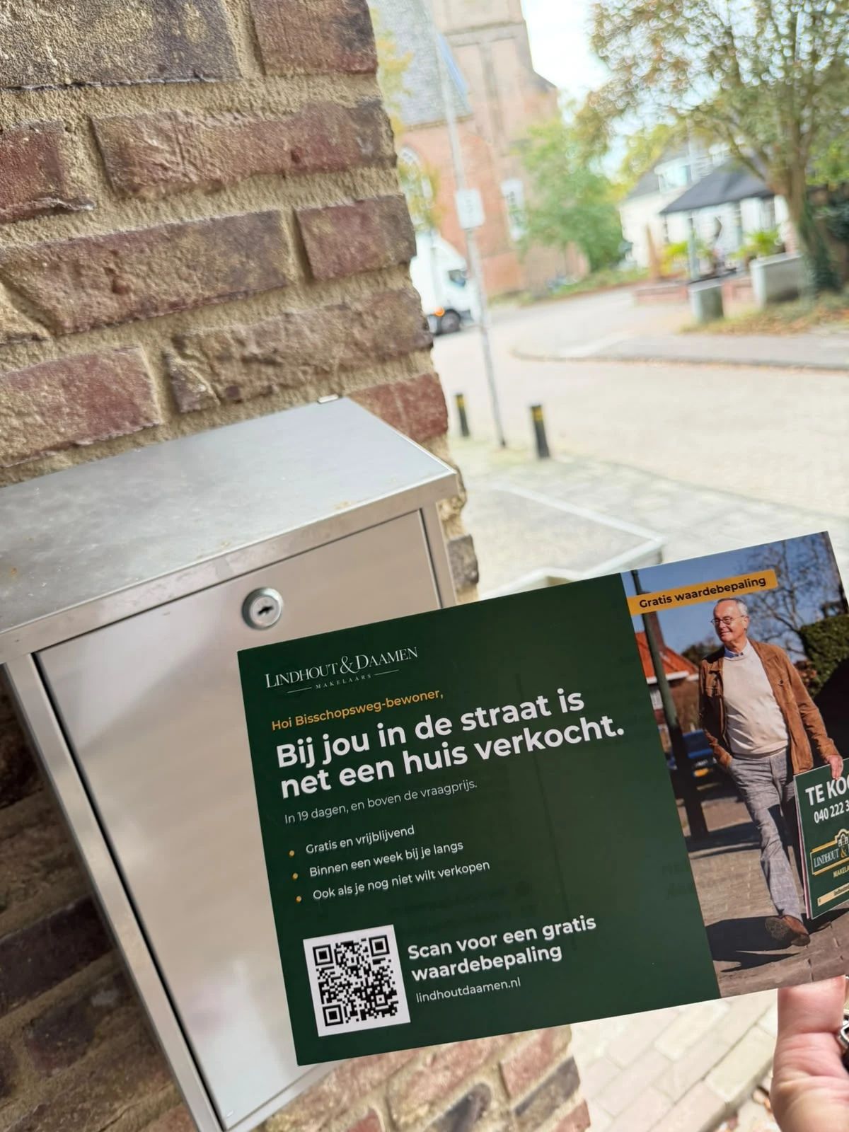 Kaart van Lindhout & Daamen met de tekst 'Bij jou in de straat is net een huis verkocht' bij een brievenbus