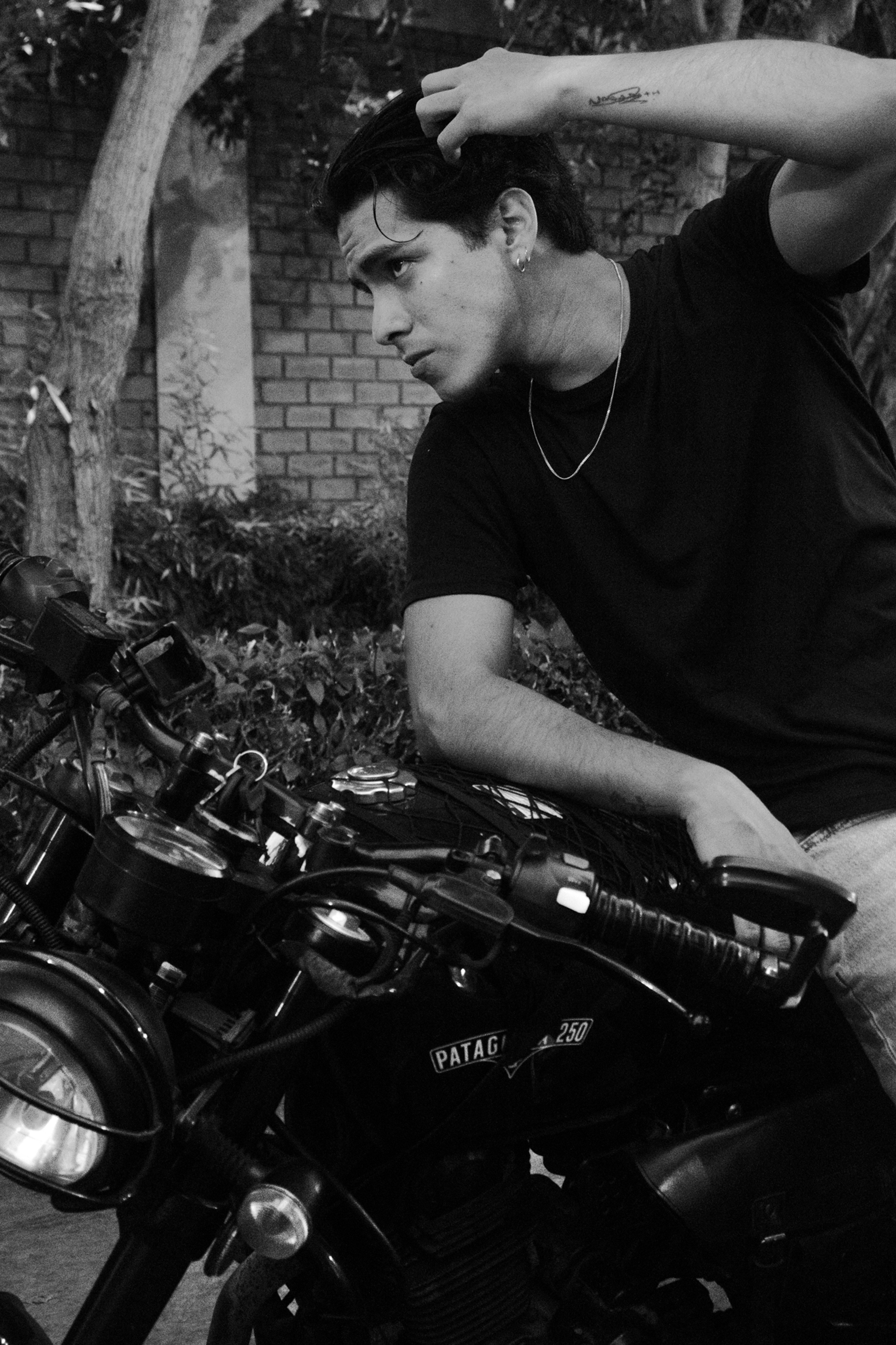 Retrato en blanco y negro de un joven sobre una motocicleta
