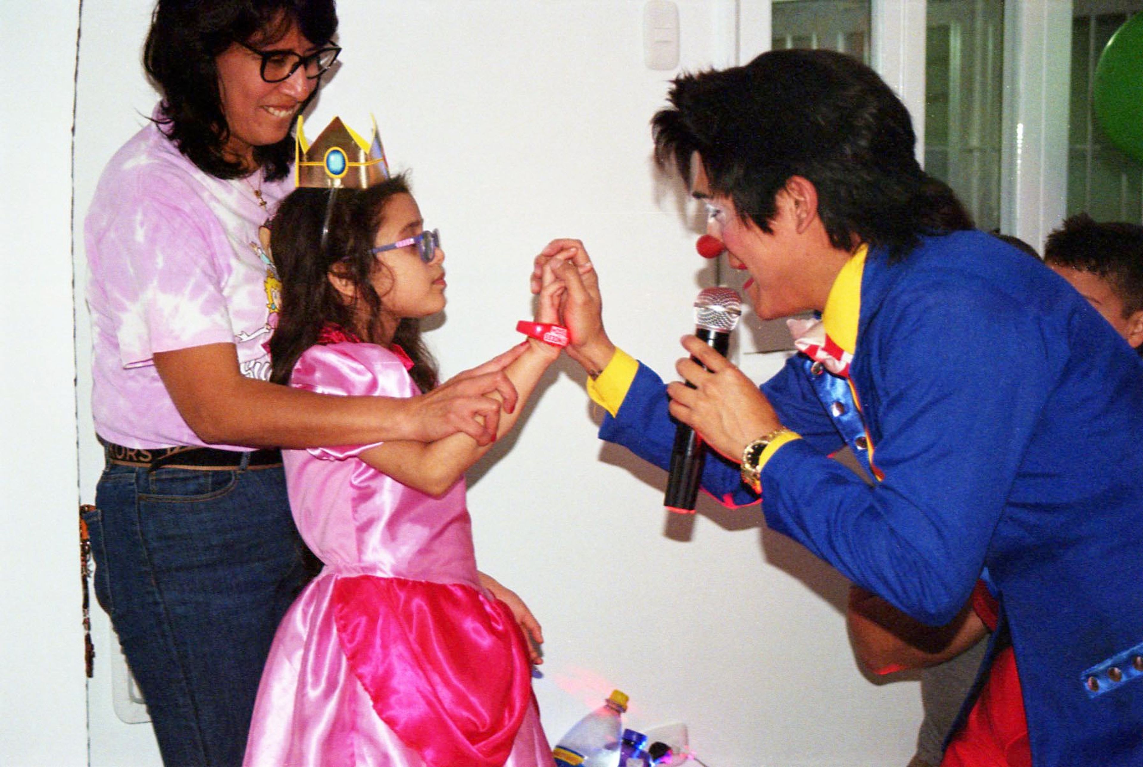 Niña con vestido de princesa interactuando con un animador que usa micrófono