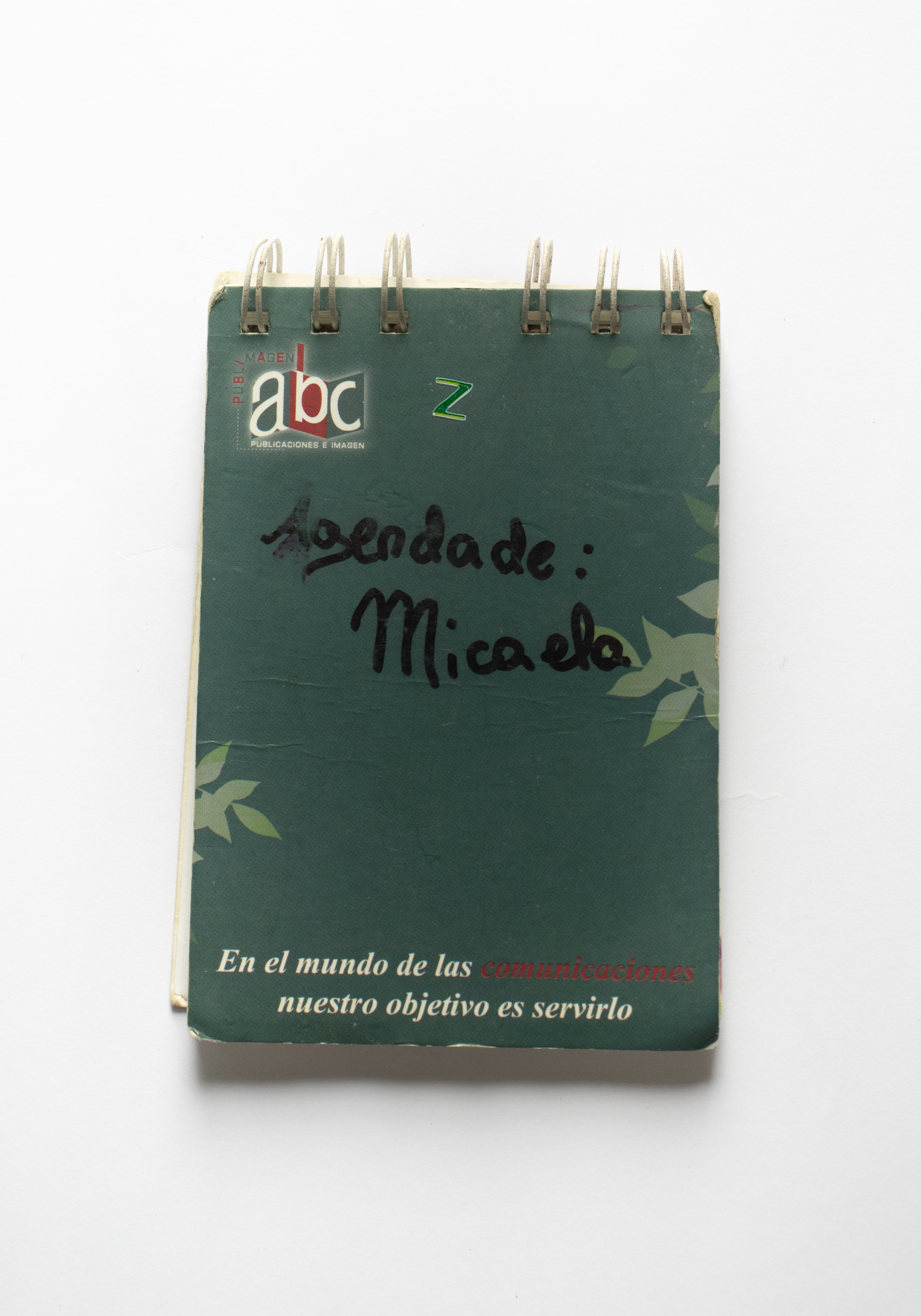 Agenda verde con nombre escrito a mano.