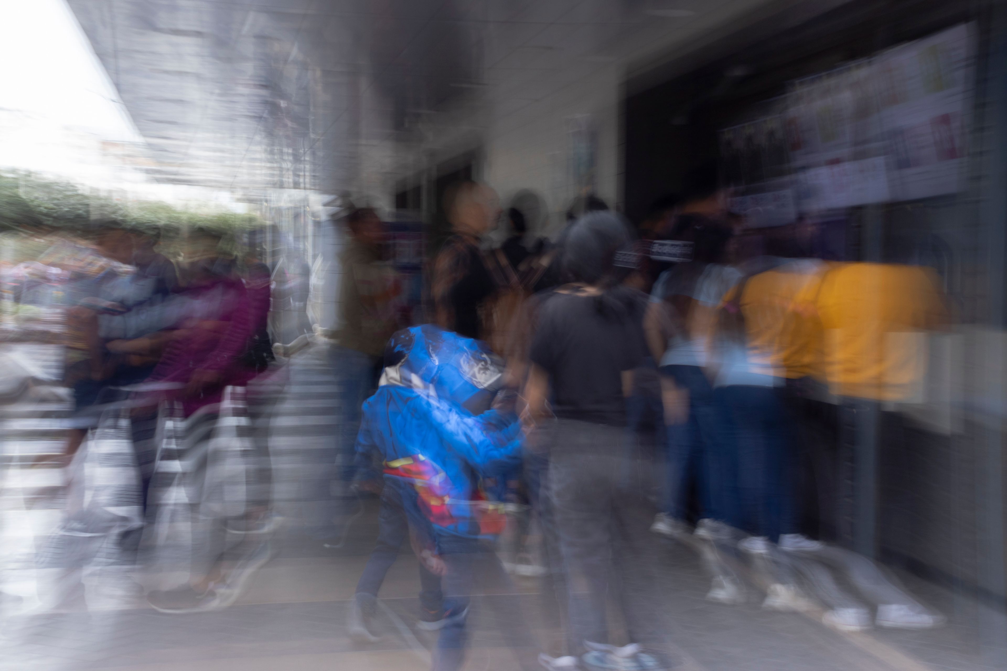 Multitud entrando a un edificio con las figuras movidas por la larga exposición