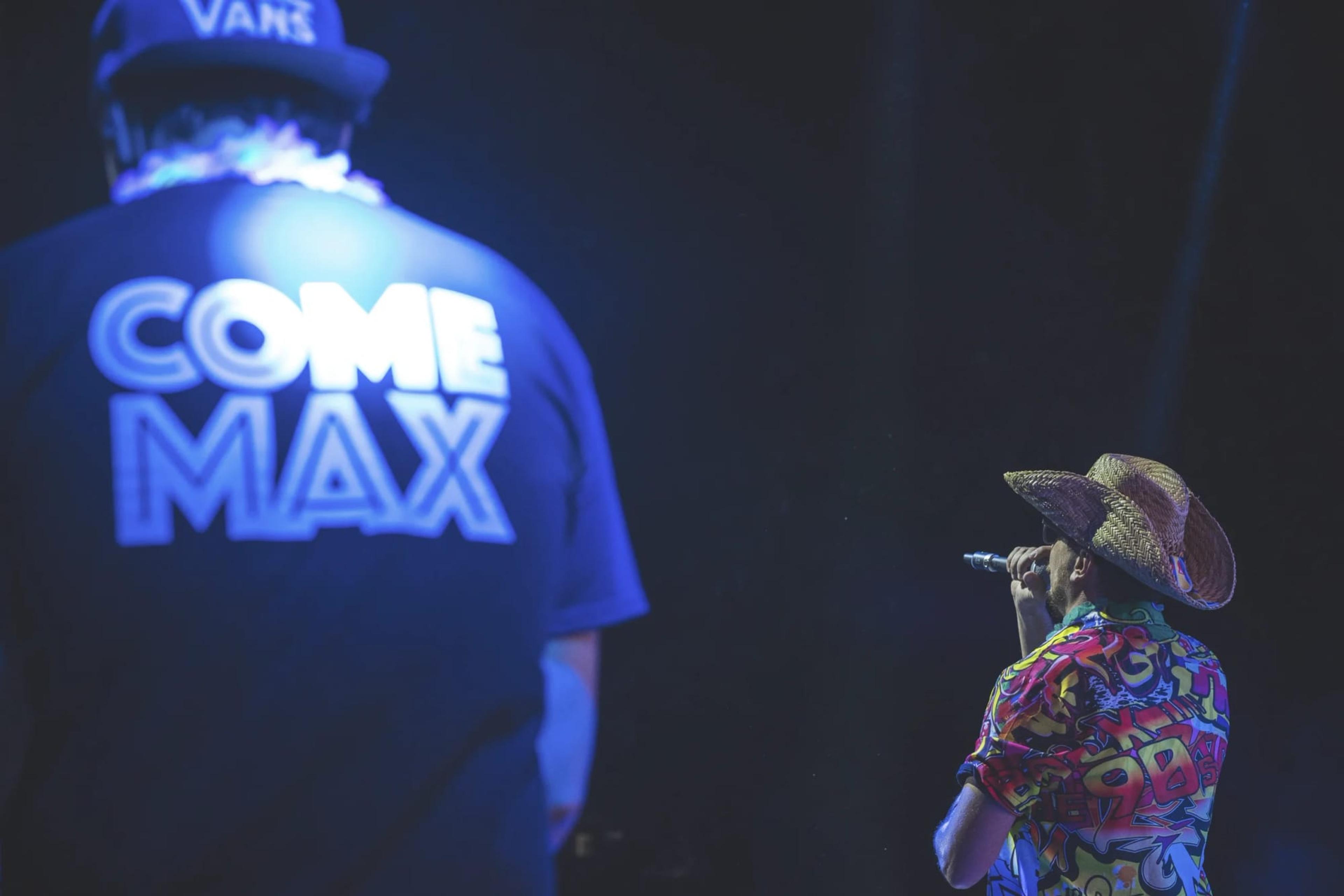 Il cantante di spalle con la maglia «Come Max» e un altro musicista sul palco