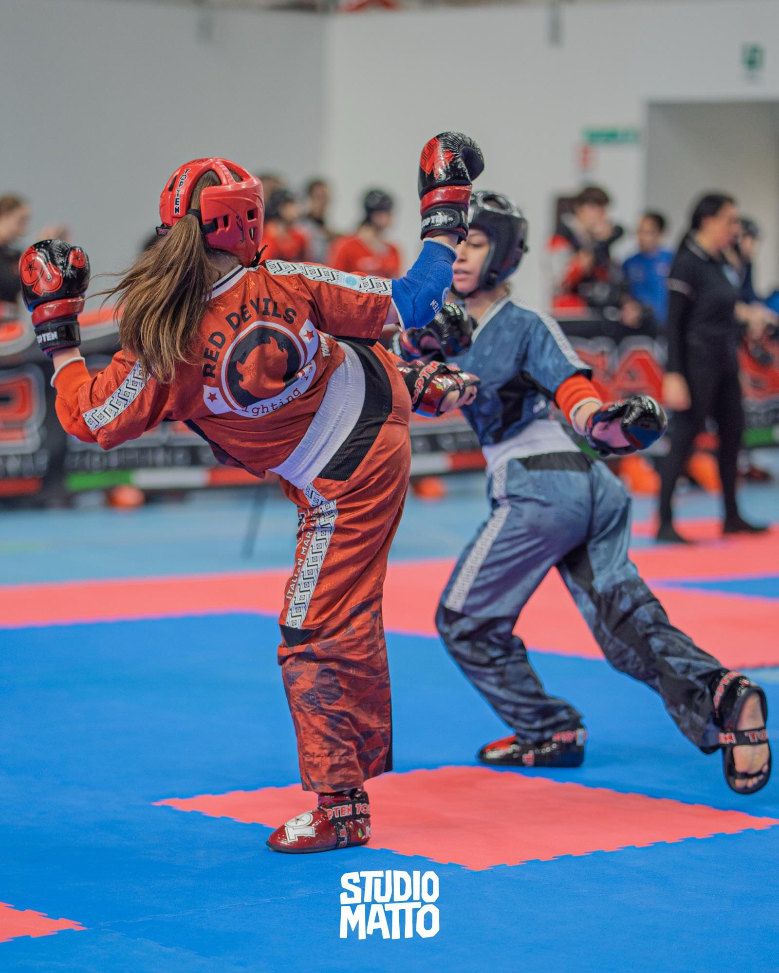 Una combattente colpisce con un calcio alto durante una gara di kickboxing