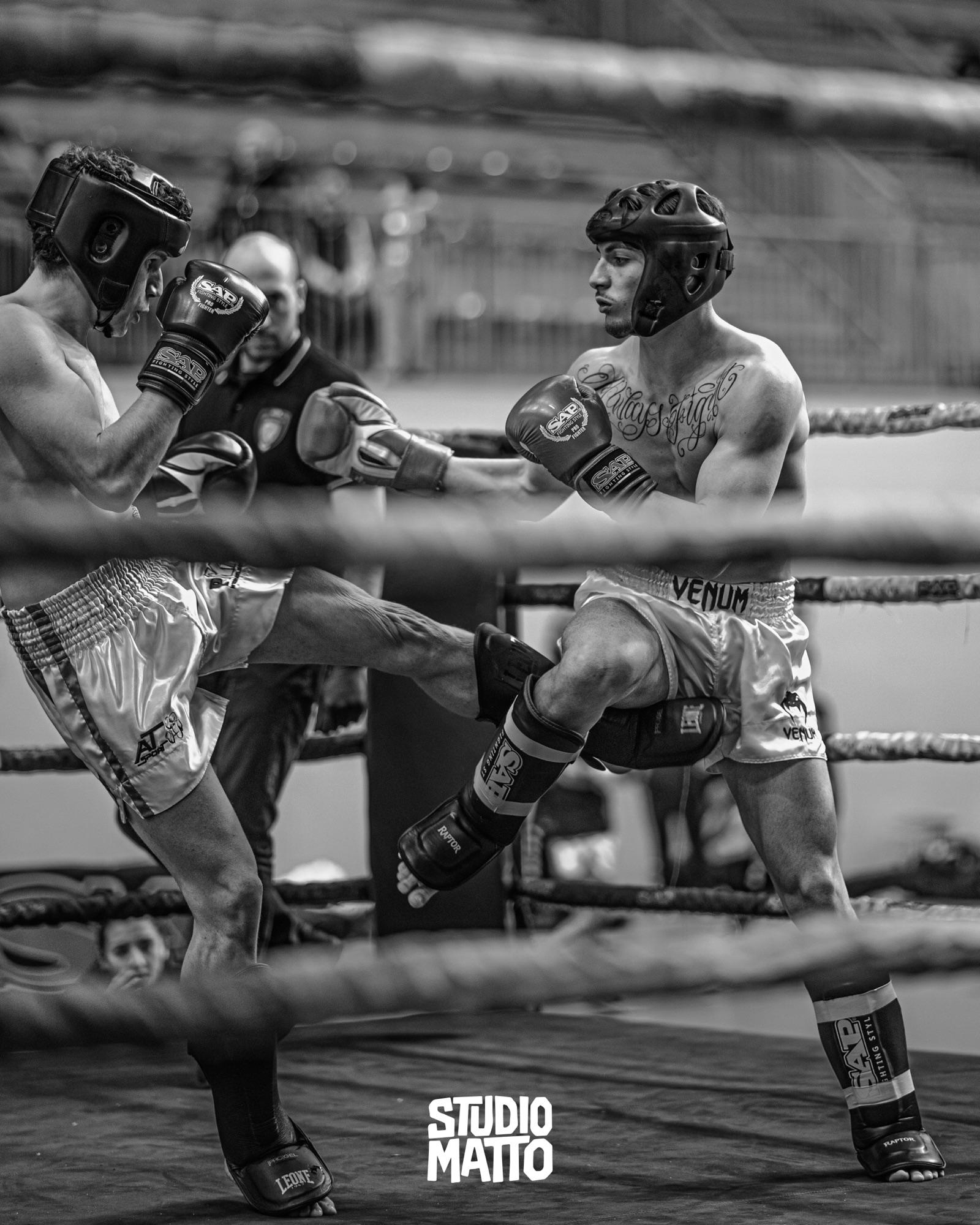 Un calcio al corpo durante un incontro sul ring, in bianco e nero