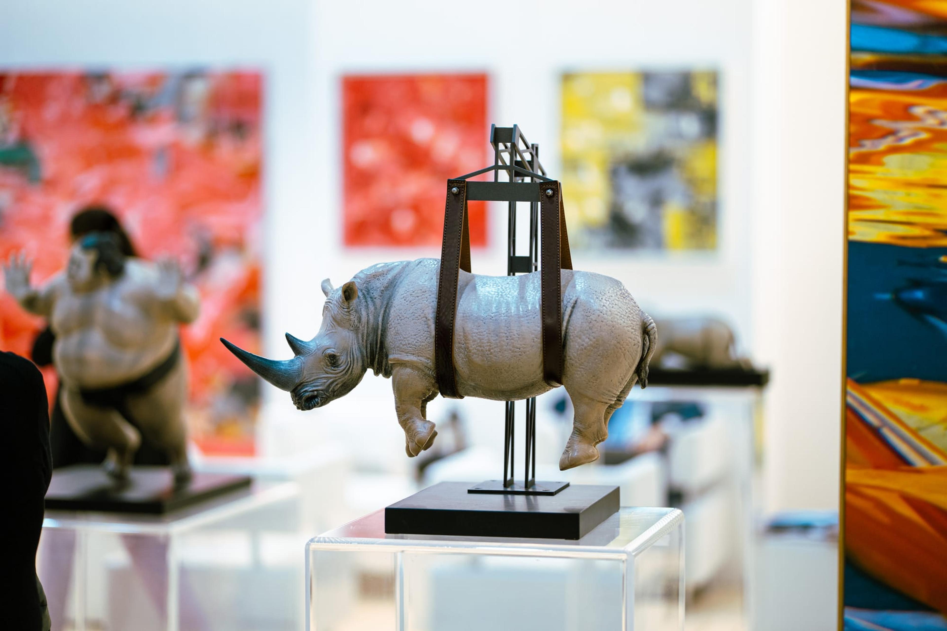 Una scultura di rinoceronte tra i dipinti dell’esposizione