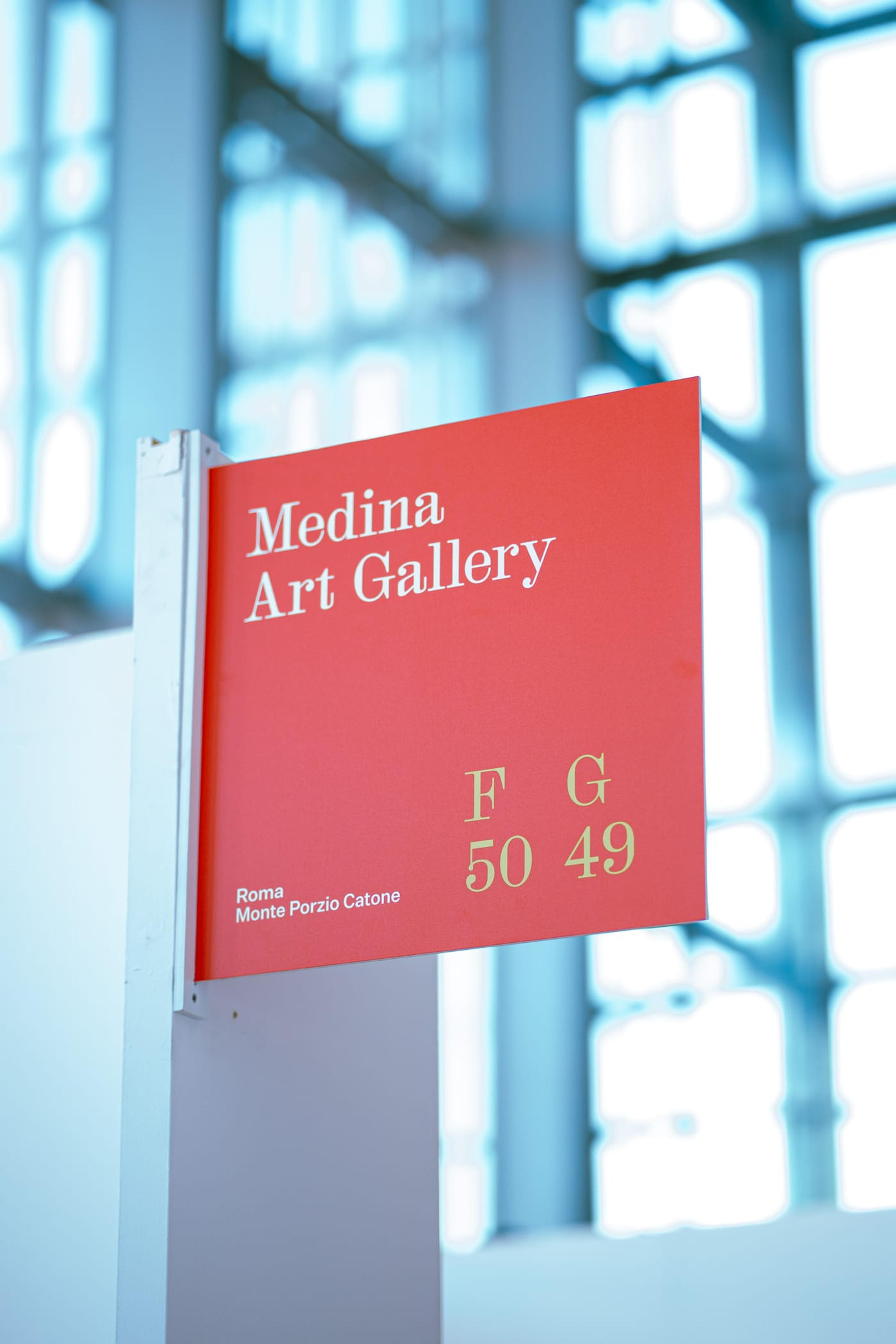 Il cartello rosso di Medina Art Gallery alla mostra