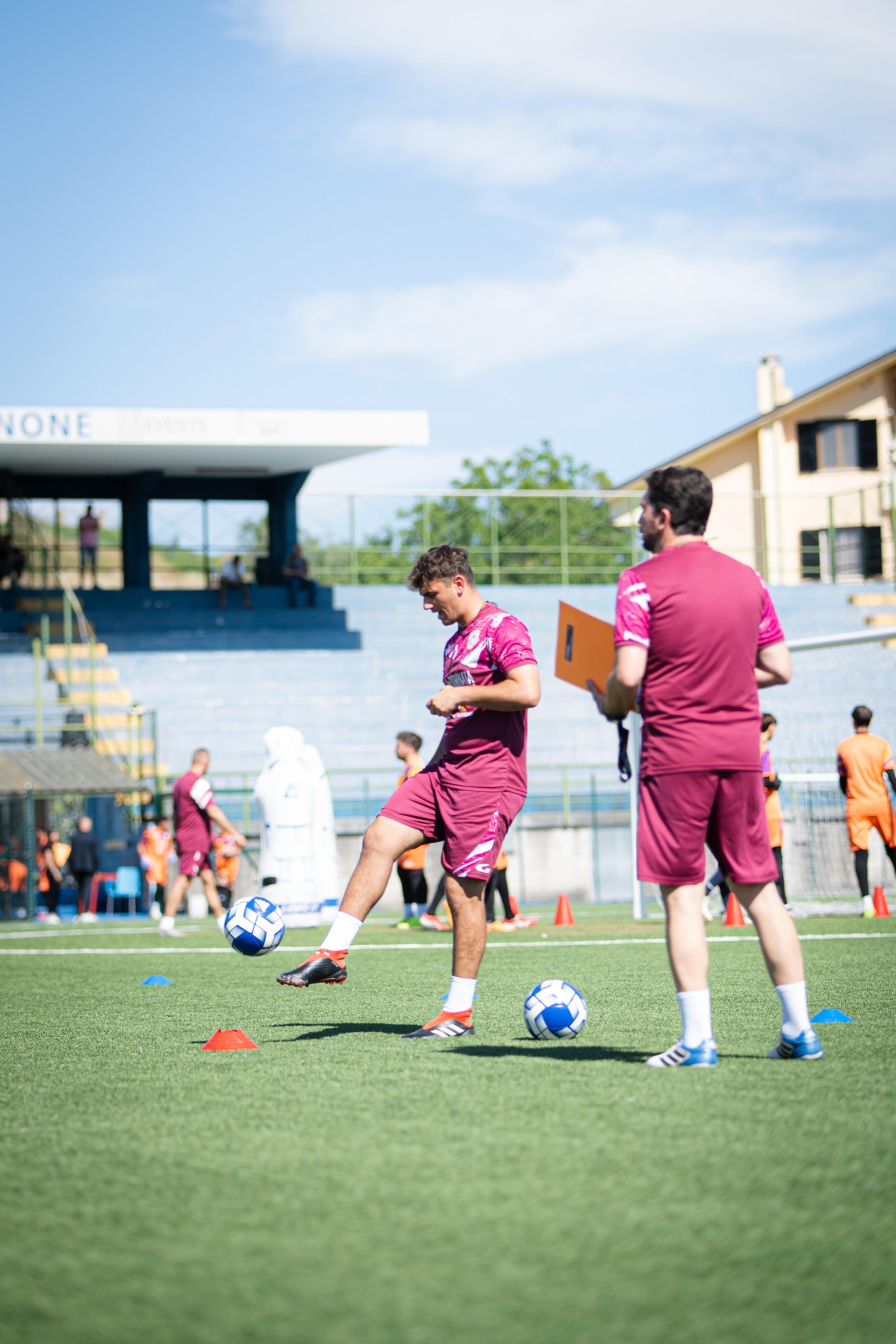 Un preparatore calcia il pallone durante l’allenamento sul campo