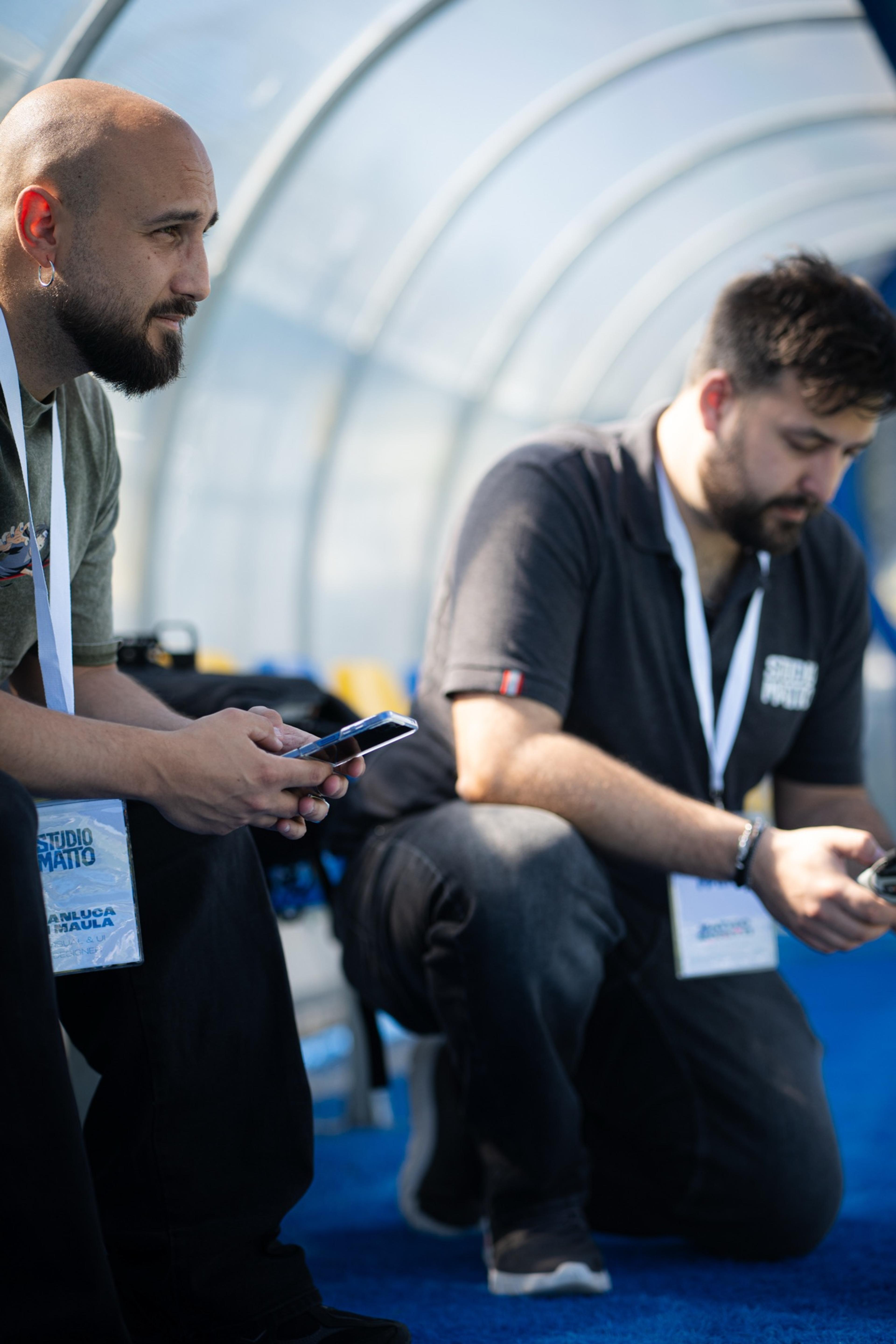 Due persone dello staff a bordo campo con i badge dell’evento