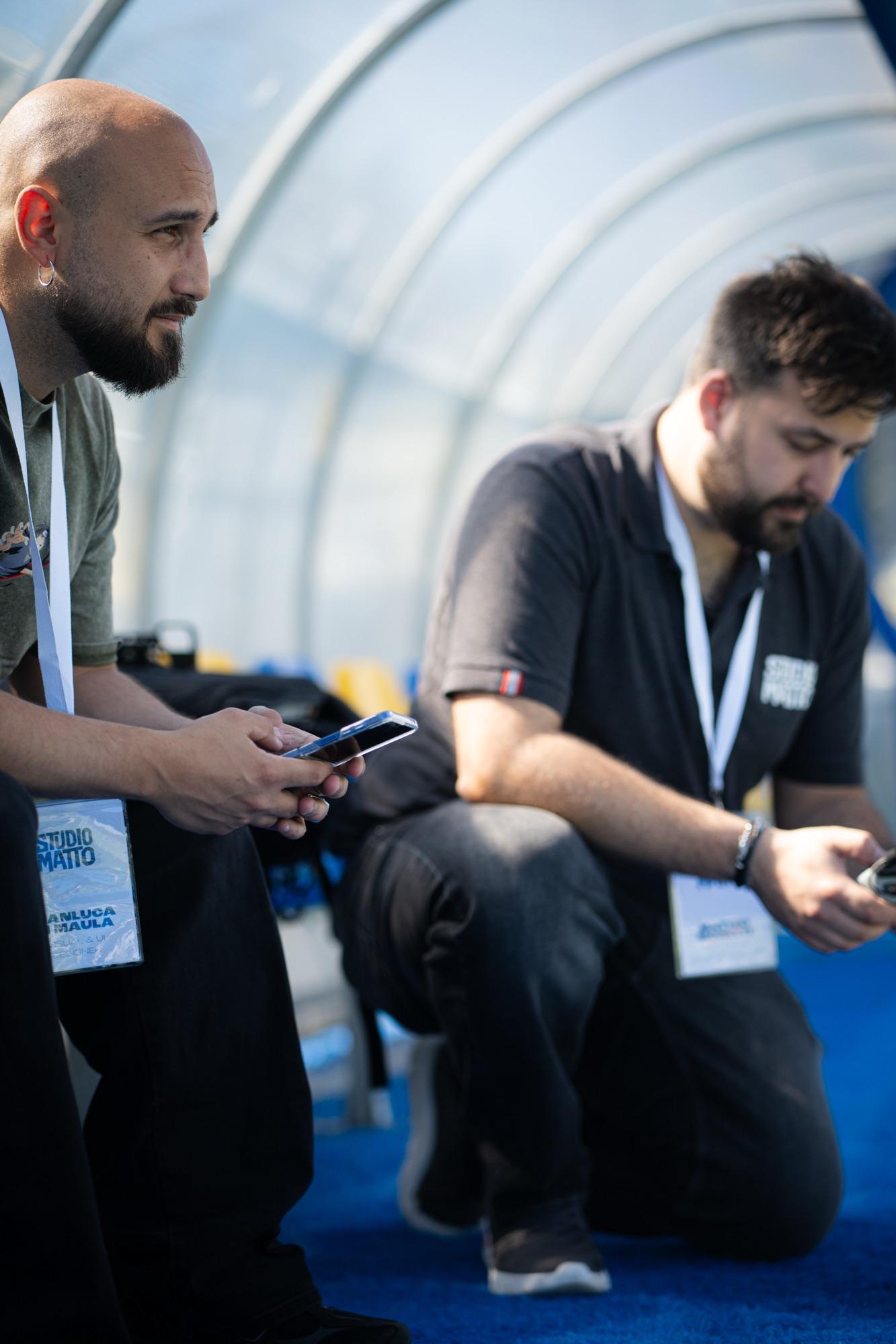 Due persone dello staff a bordo campo con i badge dell’evento