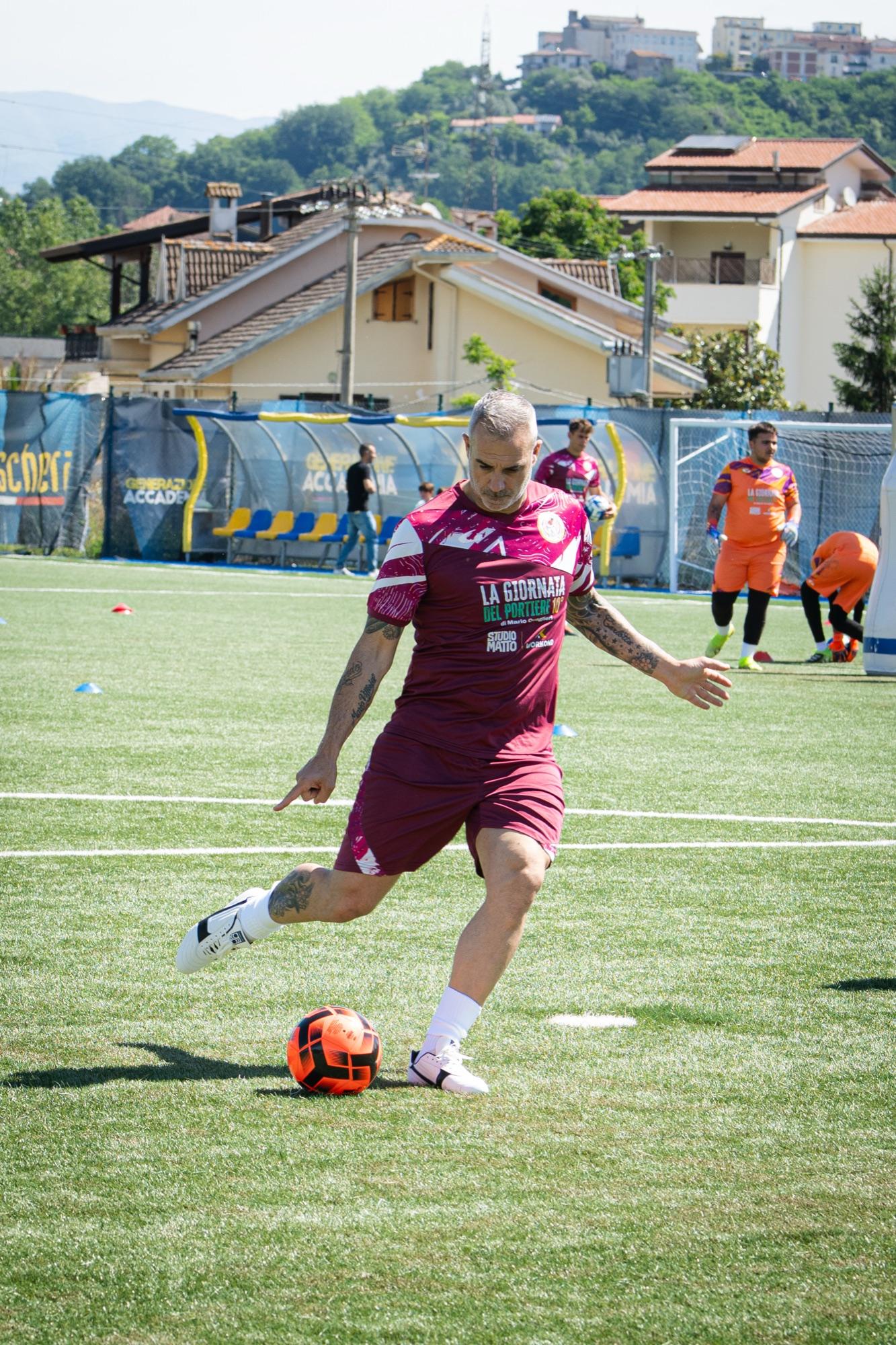 Un preparatore calcia il pallone sul campo durante la Giornata del Portiere