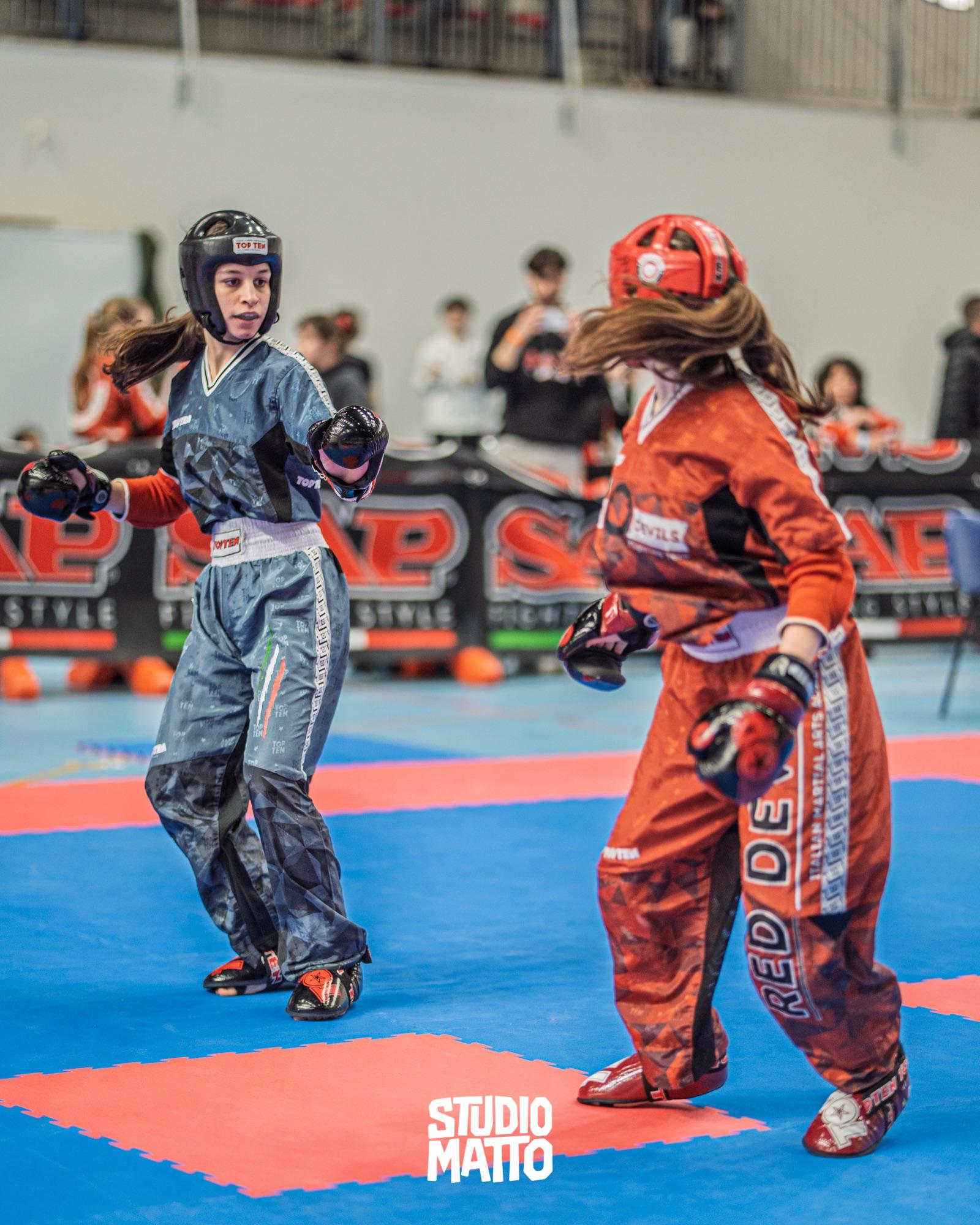 Due atlete si fronteggiano sul tatami blu durante un incontro