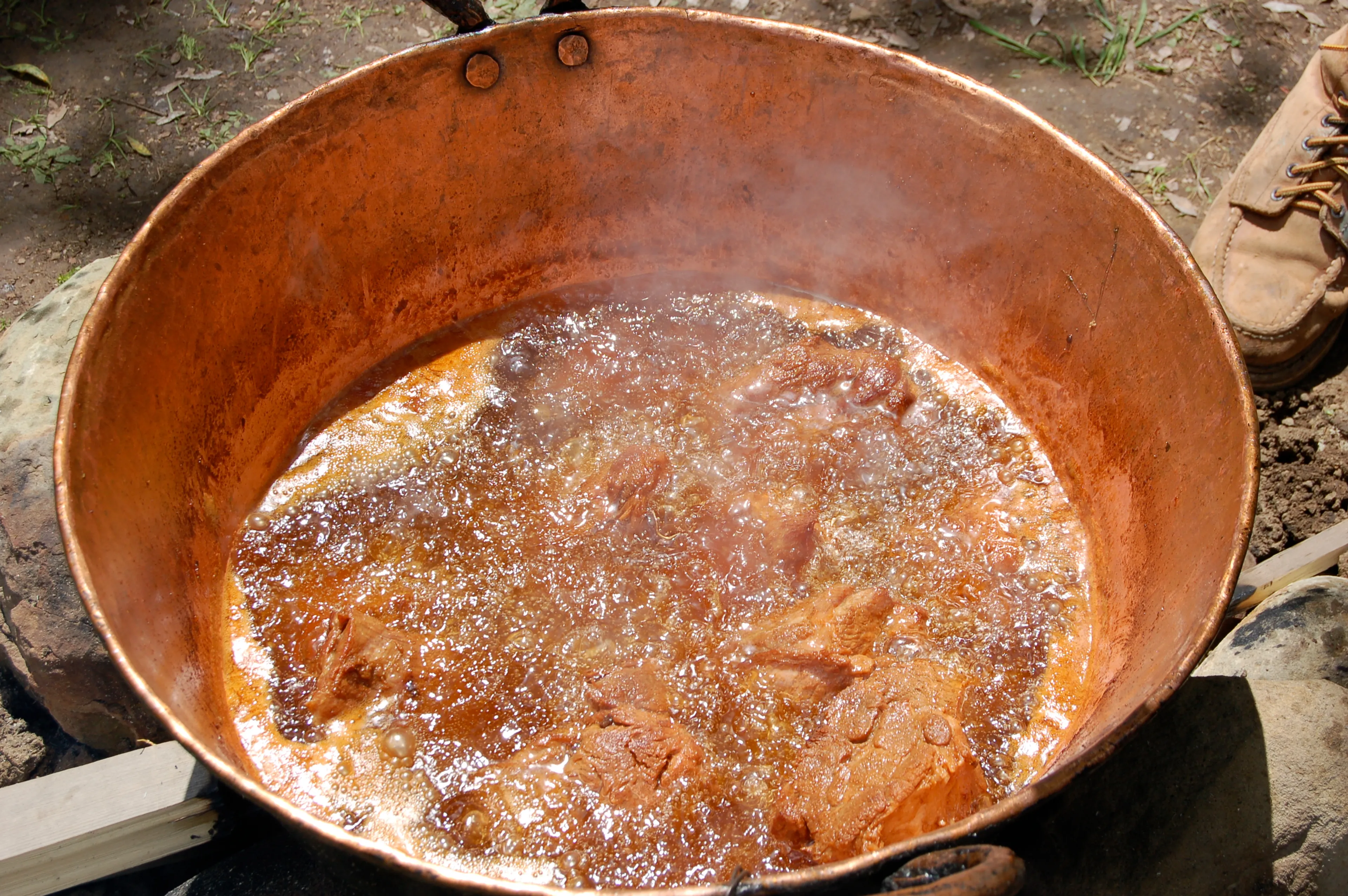 Carnitas being cooked in a traditional caso