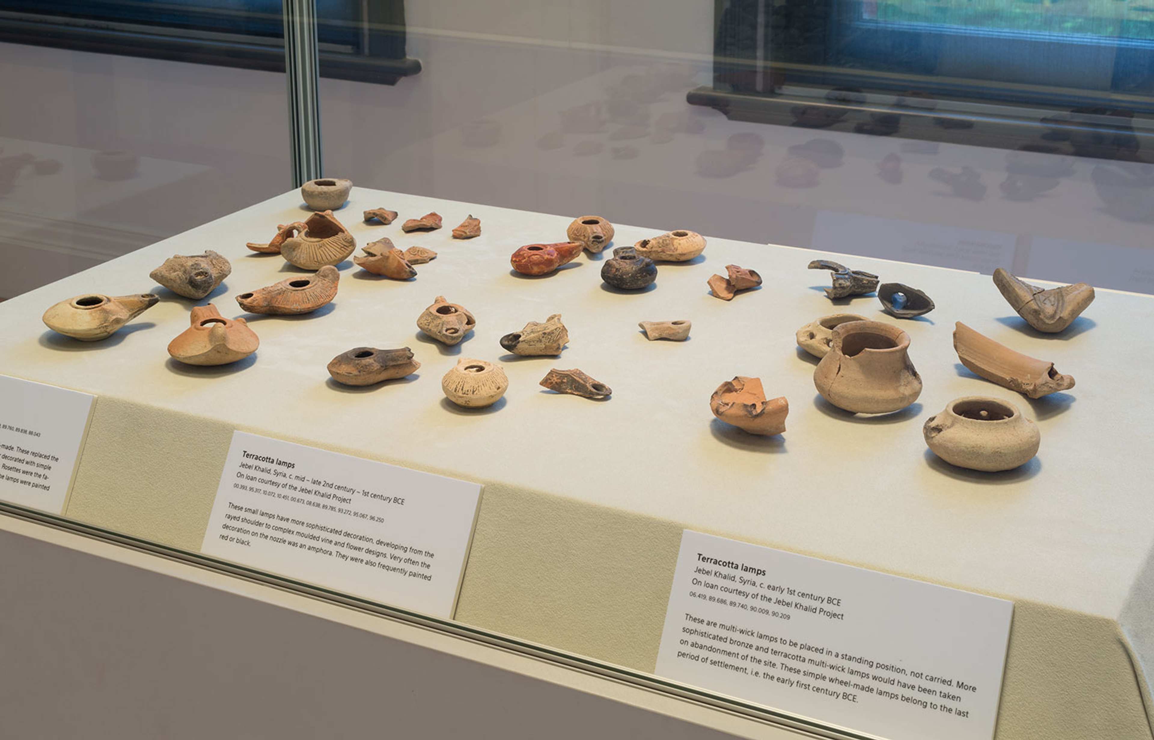 An image of a vitrine displaying small ancient ceramic vessels