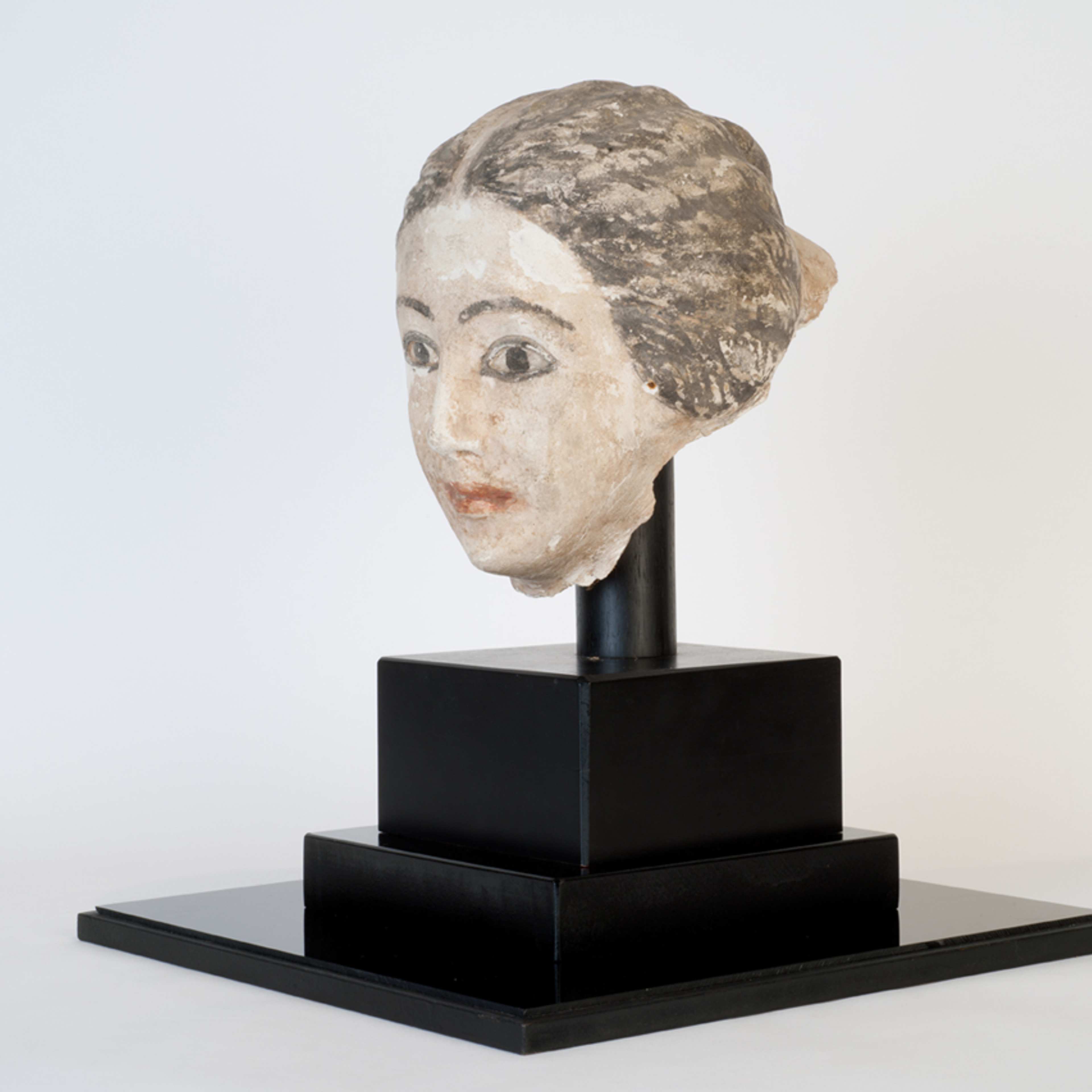 A photograph of a plaster funerary mask of a person with their hair combed back