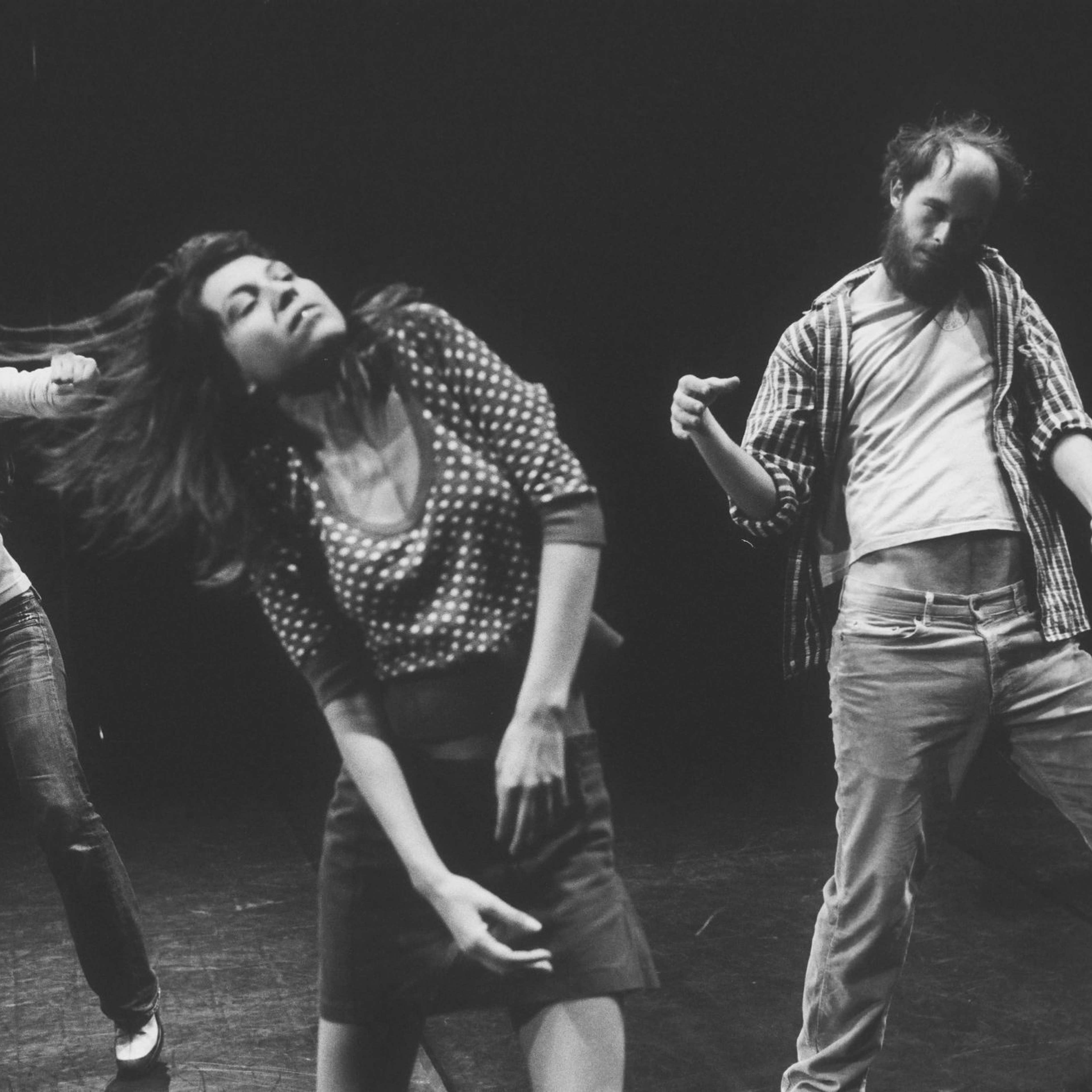 A still from a black and white film showing four people captured mid-dance