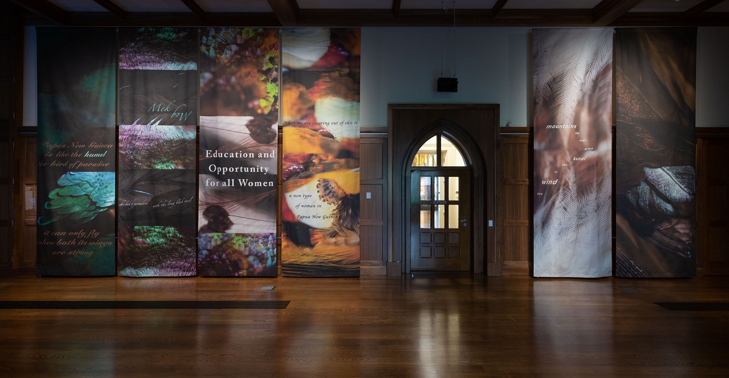 The entrance to exhibition at Old Quad gallery with floor to ceiling hanging artworks about education for women