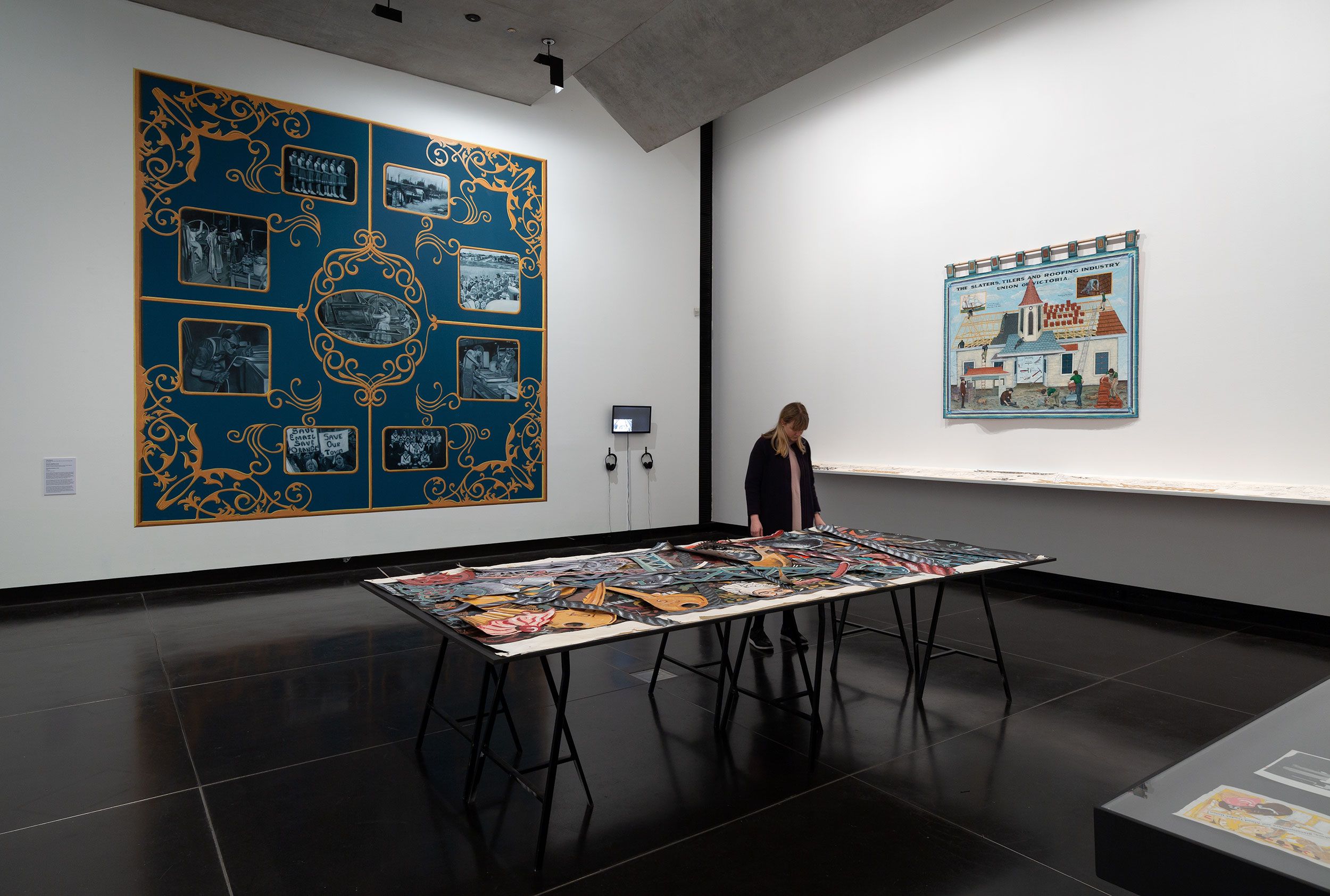 A visitor looks at art on a table in a gallery 