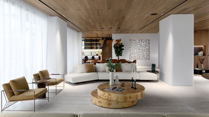 A luxurious virtual showroom interface on a tablet showcasing a sophisticated contemporary living room with sculptural sofa, marble coffee table, brass floor lamp, and Dubai skyline through floor-to-ceiling windows.