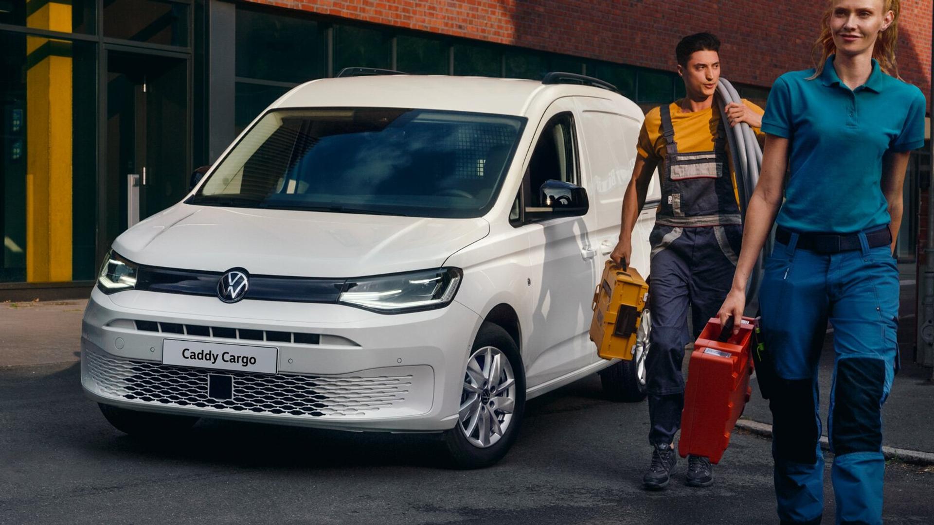 Volkswagen Caddy Cargo og to stk håndtverkere som går bort fra den og bærer på verktøy