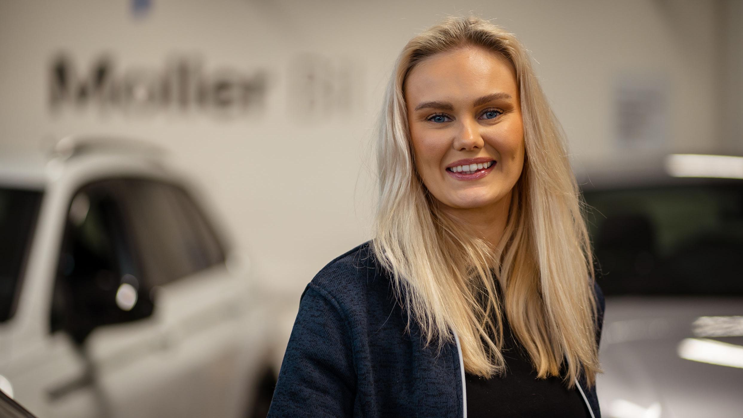 Kvinnelig Møller Bil ansatt på bruktbil som smiler