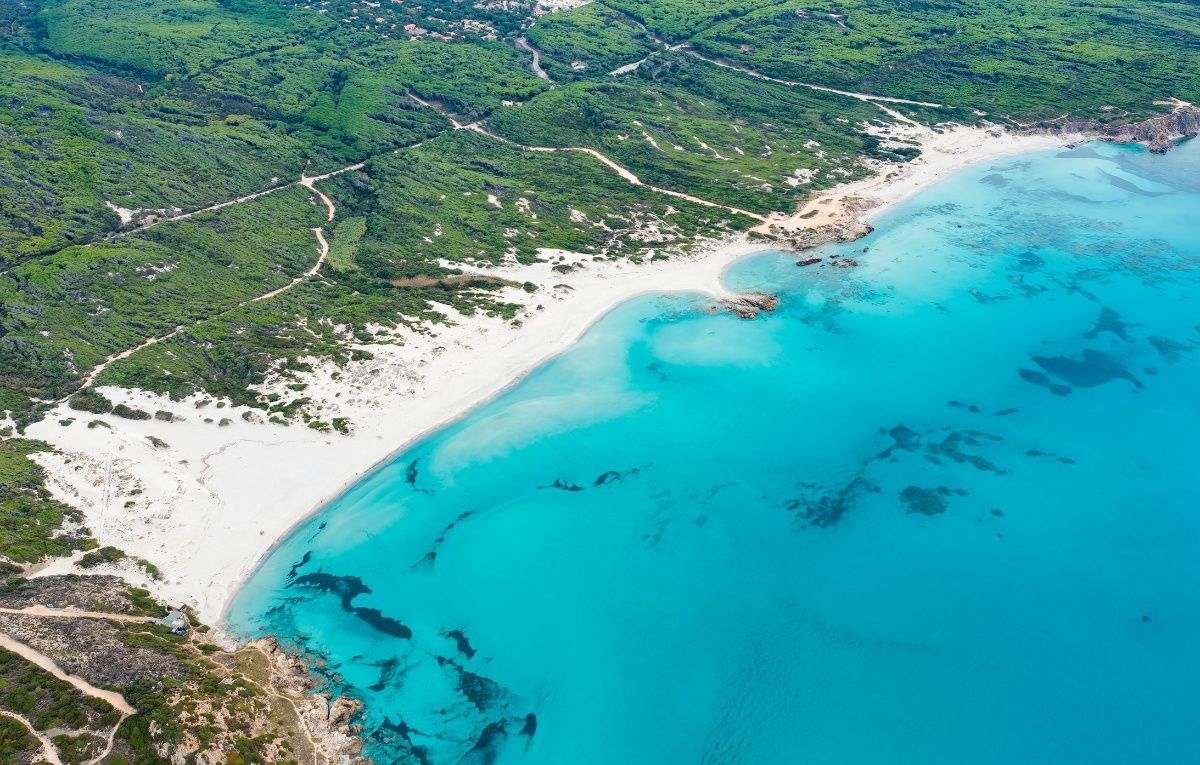 View from above, stunning aerial view of a white sand beach bathed by a turquoise water. Rena Majore, Sardinia, Italy.