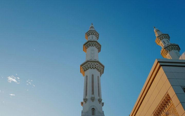 Seorang muslim sedang bersiap menunaikan ibadah salat dengan khusyuk di ruangan yang tenang dan rapi.
