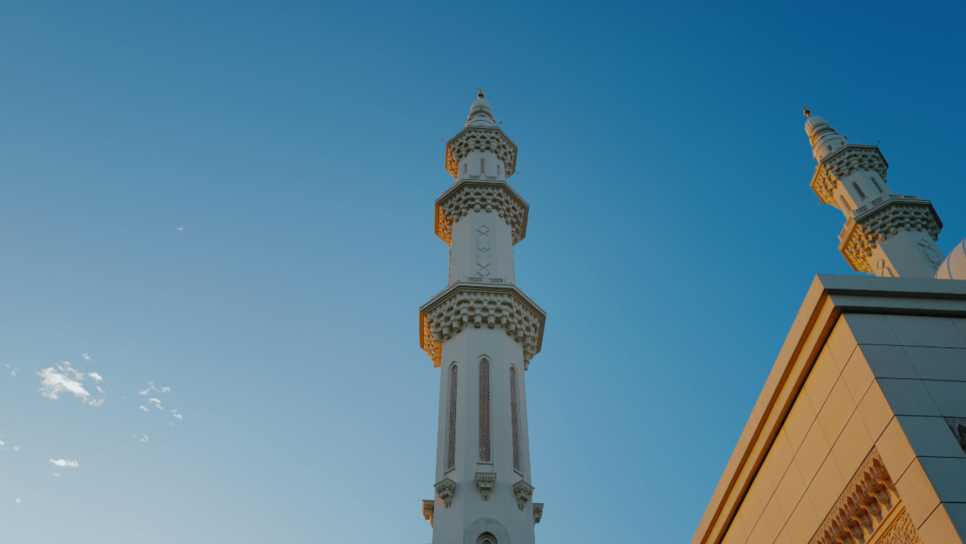 Seorang muslim sedang bersiap menunaikan ibadah salat dengan khusyuk di ruangan yang tenang dan rapi.