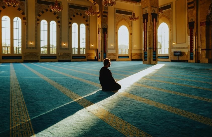 Ilustrasi seseorang sedang merenungkan Al-Qur'an dengan cahaya lembut penuh kedamaian