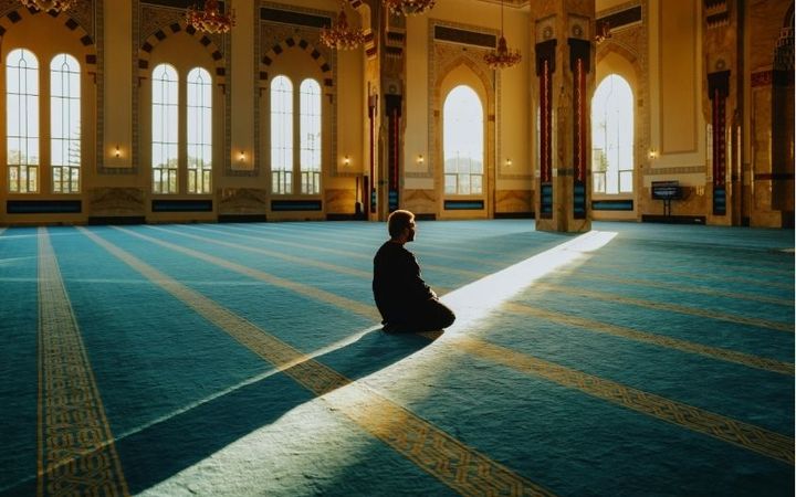 Ilustrasi seseorang sedang merenungkan Al-Qur'an dengan cahaya lembut penuh kedamaian
