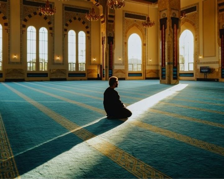 Ilustrasi seseorang sedang merenungkan Al-Qur'an dengan cahaya lembut penuh kedamaian