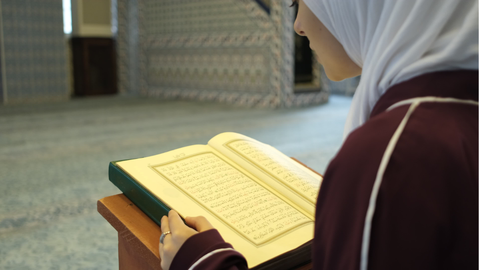Seorang wanita muslimah sedang tersenyum teduh dengan latar belakang pemandangan yang menenangkan dan islami.