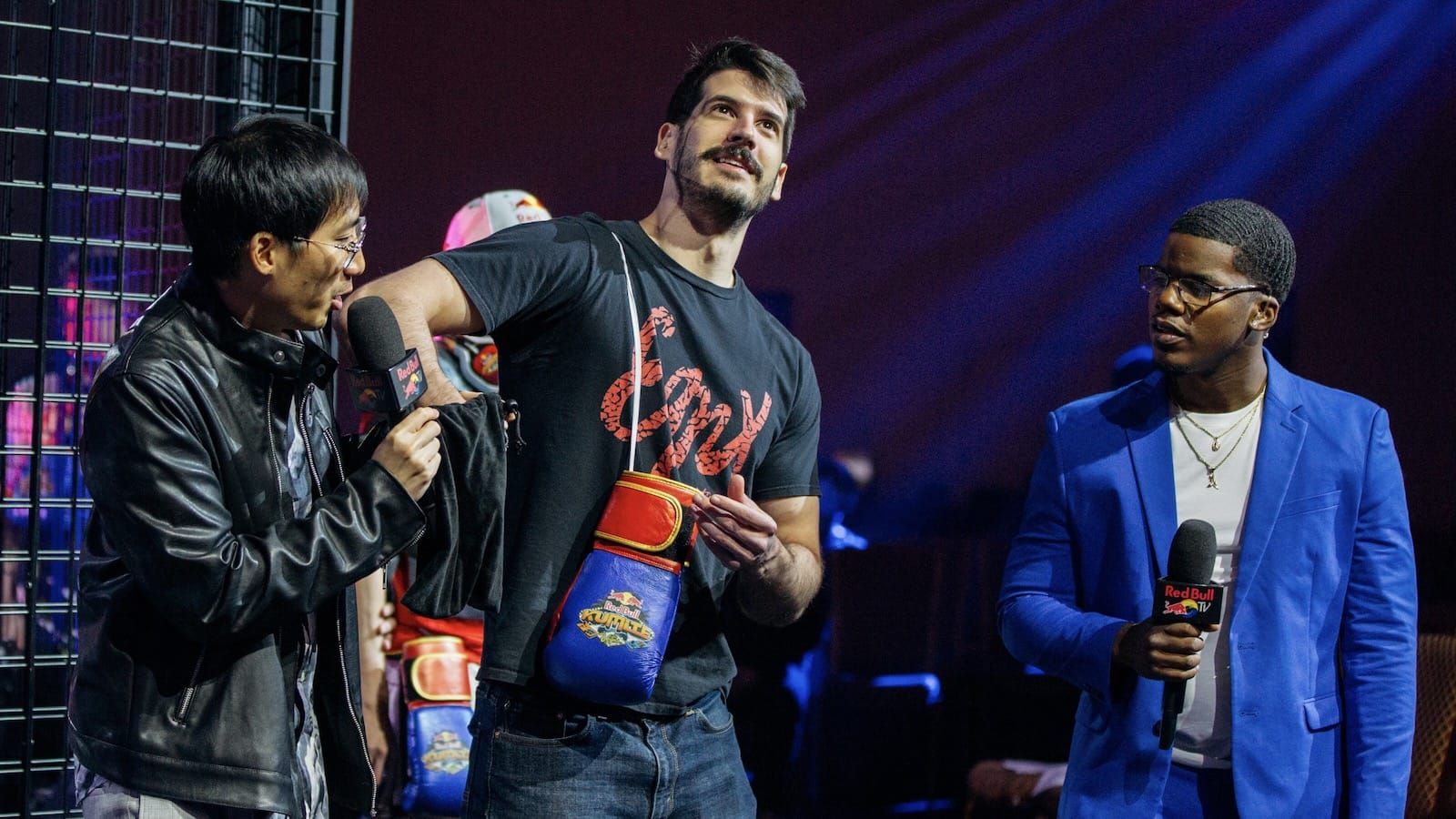 Fighting game player Brian_F on stage in between two other people at Red Bull Kumite