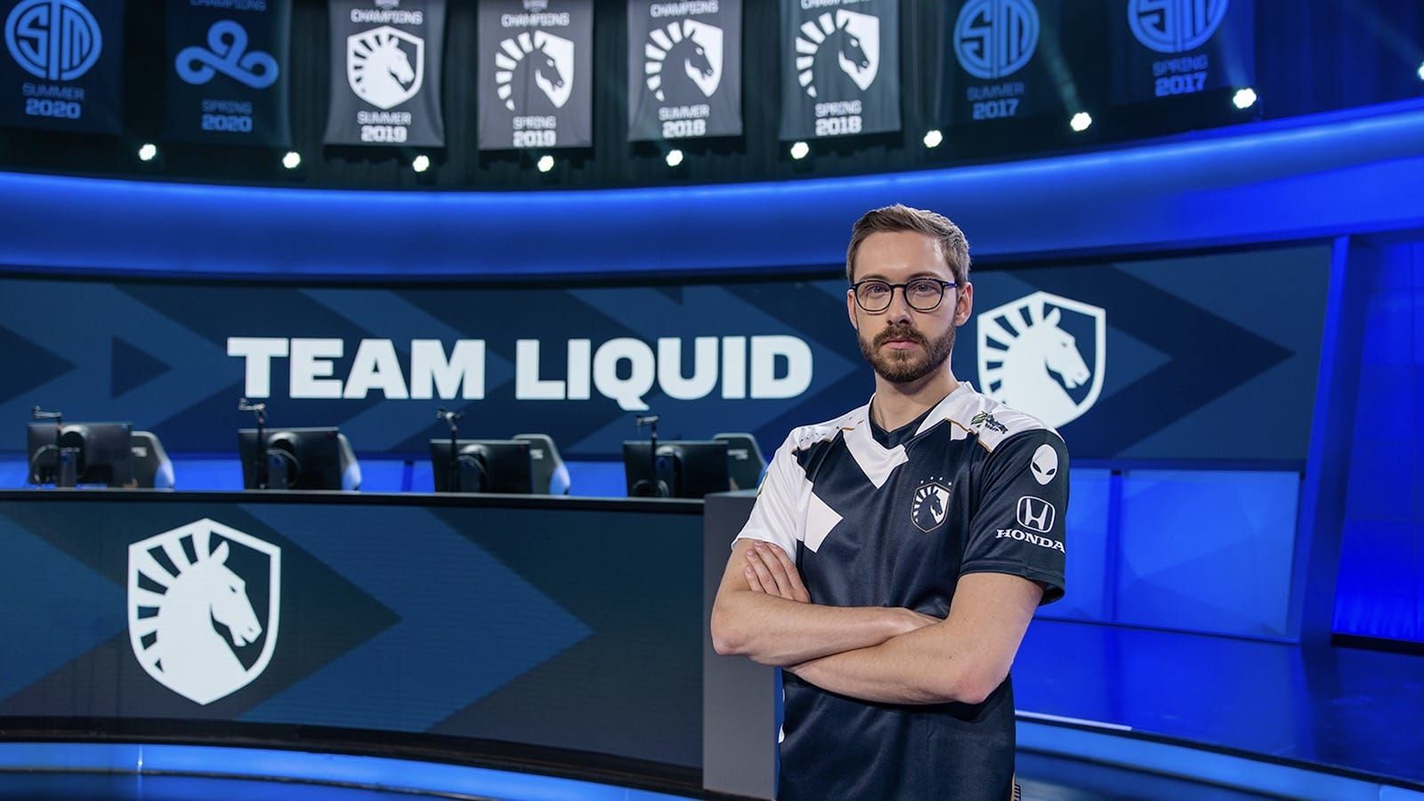 League of legends player Bjergsen poses on the LCS stage with his new Team Liquid jersey and the team name in the background