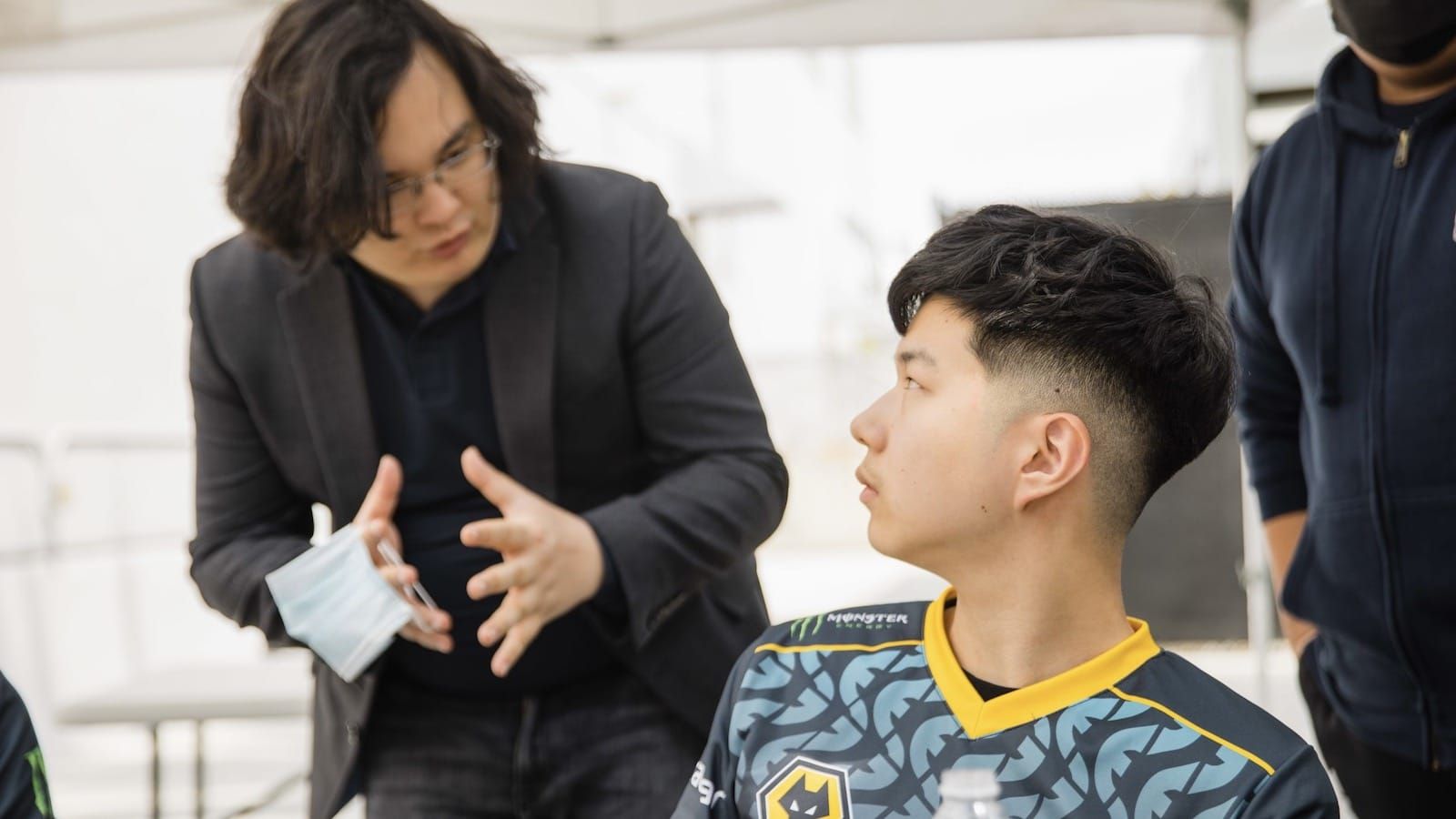 Evil Geniuses coach Peter Dun discussed something over the shoulder of player jojopyun who turns back to listen