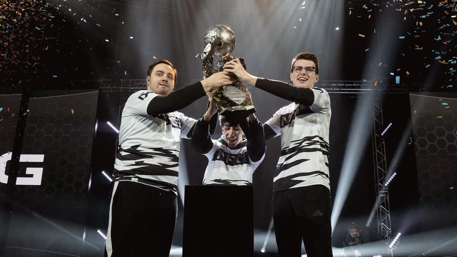 three members of NRG Rocket League team  lift a trophy after winning a championship