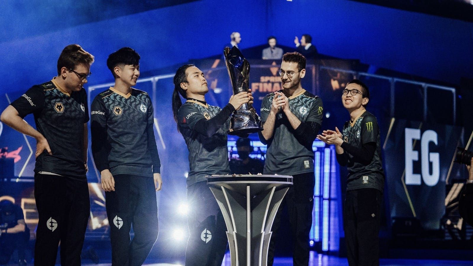 Evil Geniuses League of Legends team on stage after Spring 2022 finals win lifting trophy