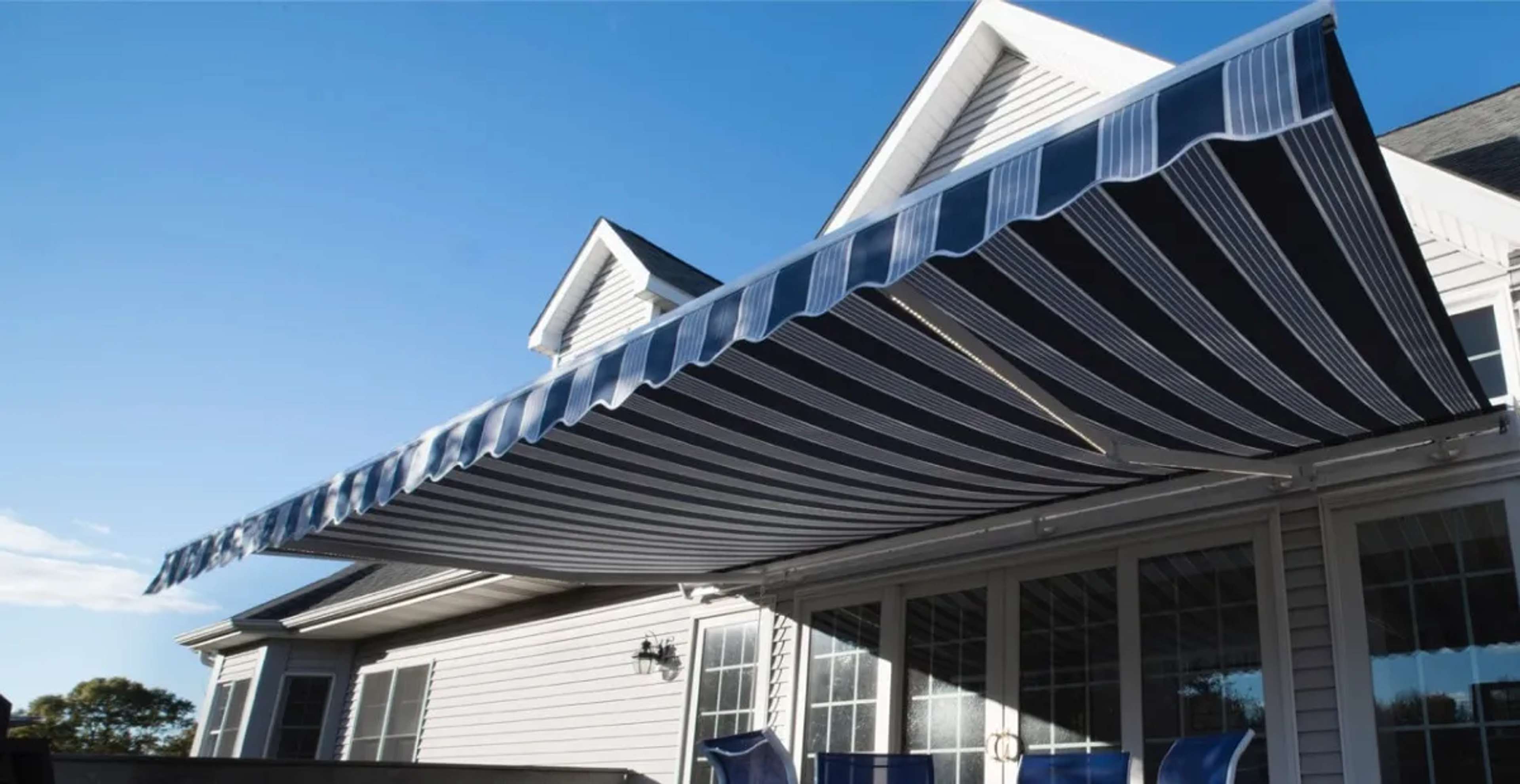 SunPro retractable awning with striped fabric extended over a residential patio.