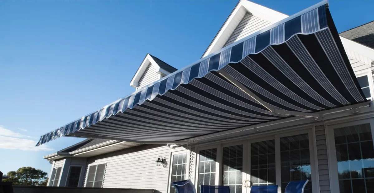 SunPro retractable awning with striped fabric extended over a residential patio.