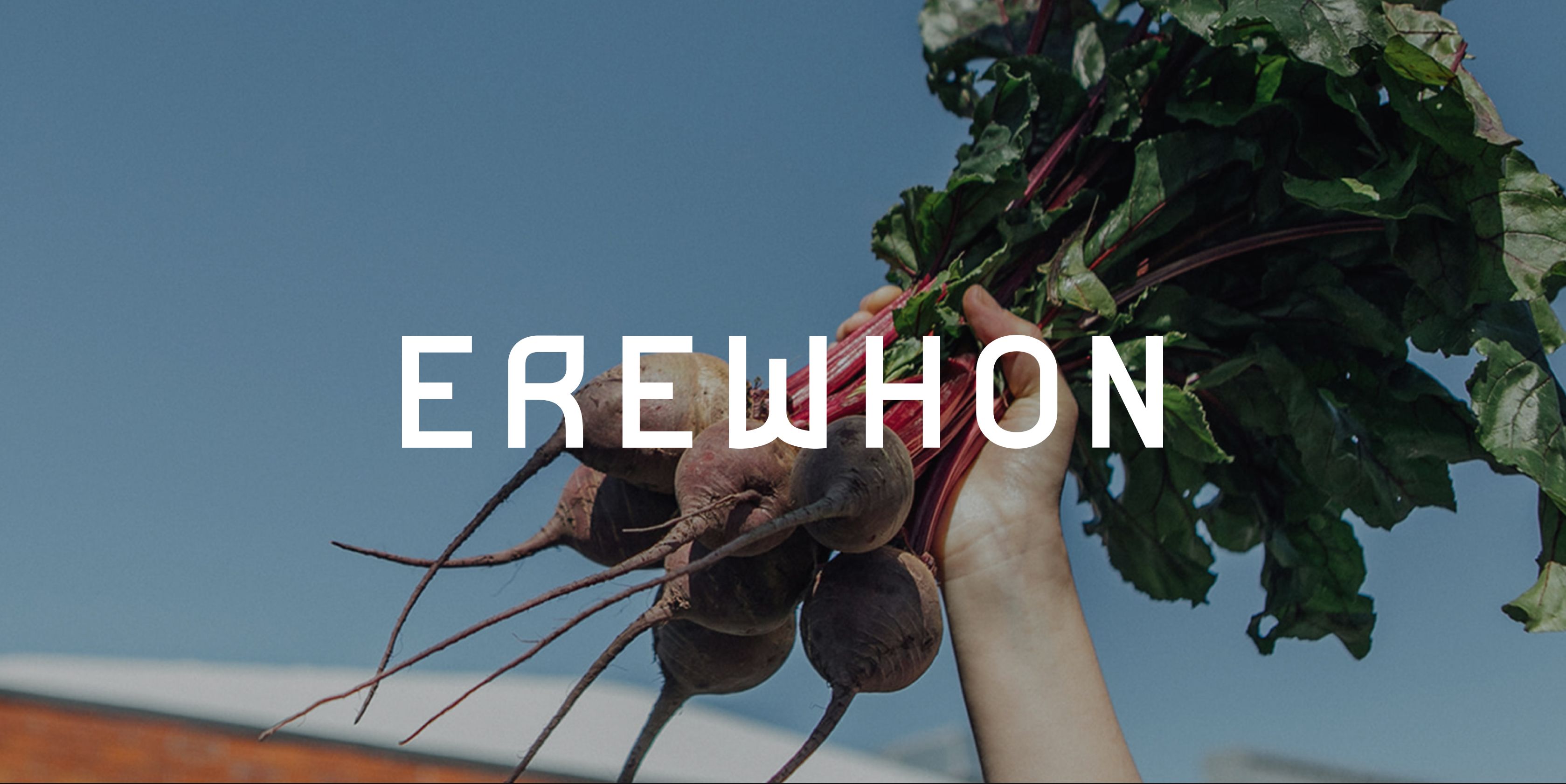Erewhon logo overlayed on a hand holding a bunch of beets