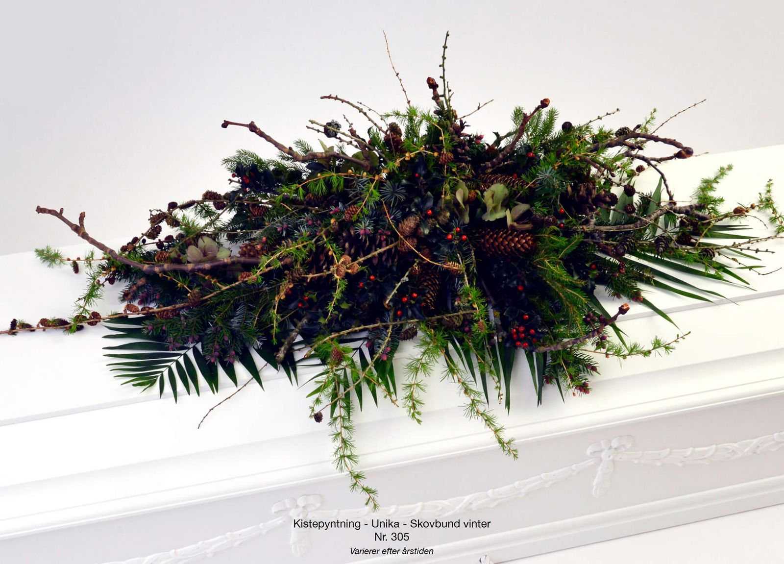 Product photography and art direction showcasing funeral arrangement with evergreen branches, red berries and botanical styling