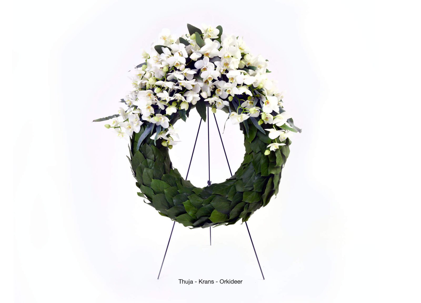 Product photography and art direction showcasing white orchid wreath with verdant foliage for funeral arrangements