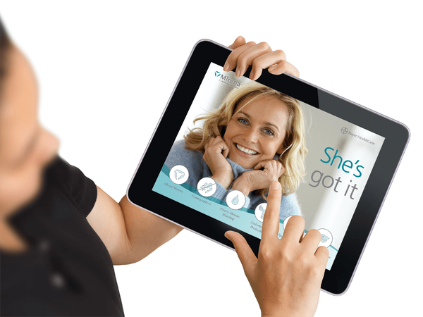 Person holder iPad med Mirena 'She's got it' app fra Bayer HealthCare — UX/UI-design og digital medicinsk detailing til sundhedsprofessionelle