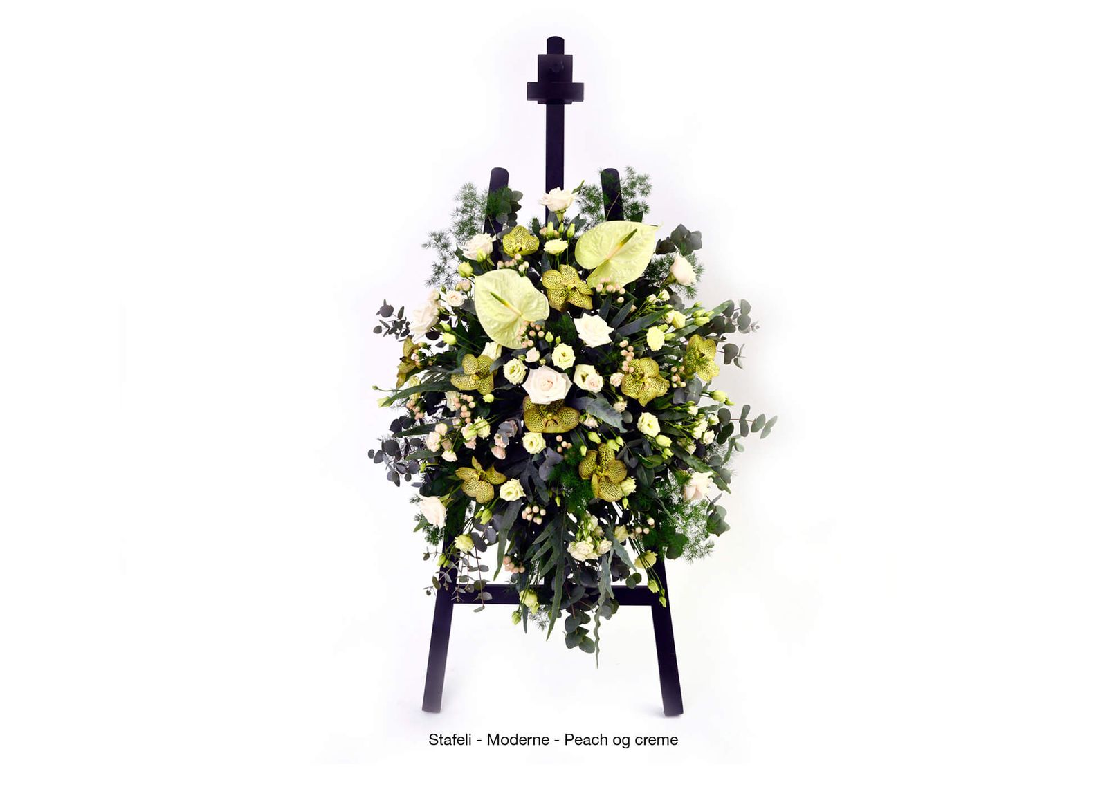Art direction of funeral arrangements featuring yellow and white flowers with black cross on easel