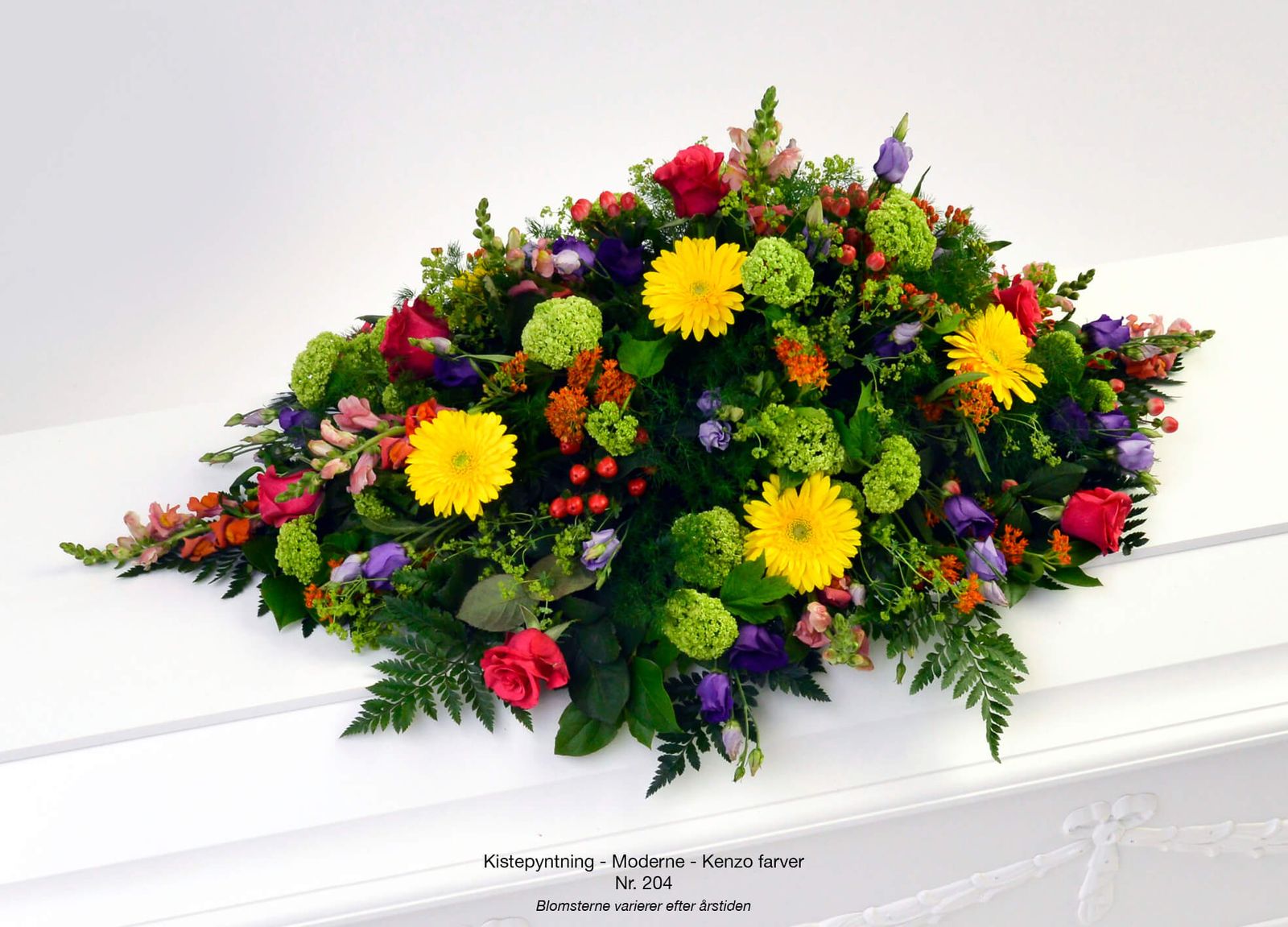 Product photography styling of vibrant funeral arrangements featuring yellow gerberas, red roses and purple flowers in elegant display