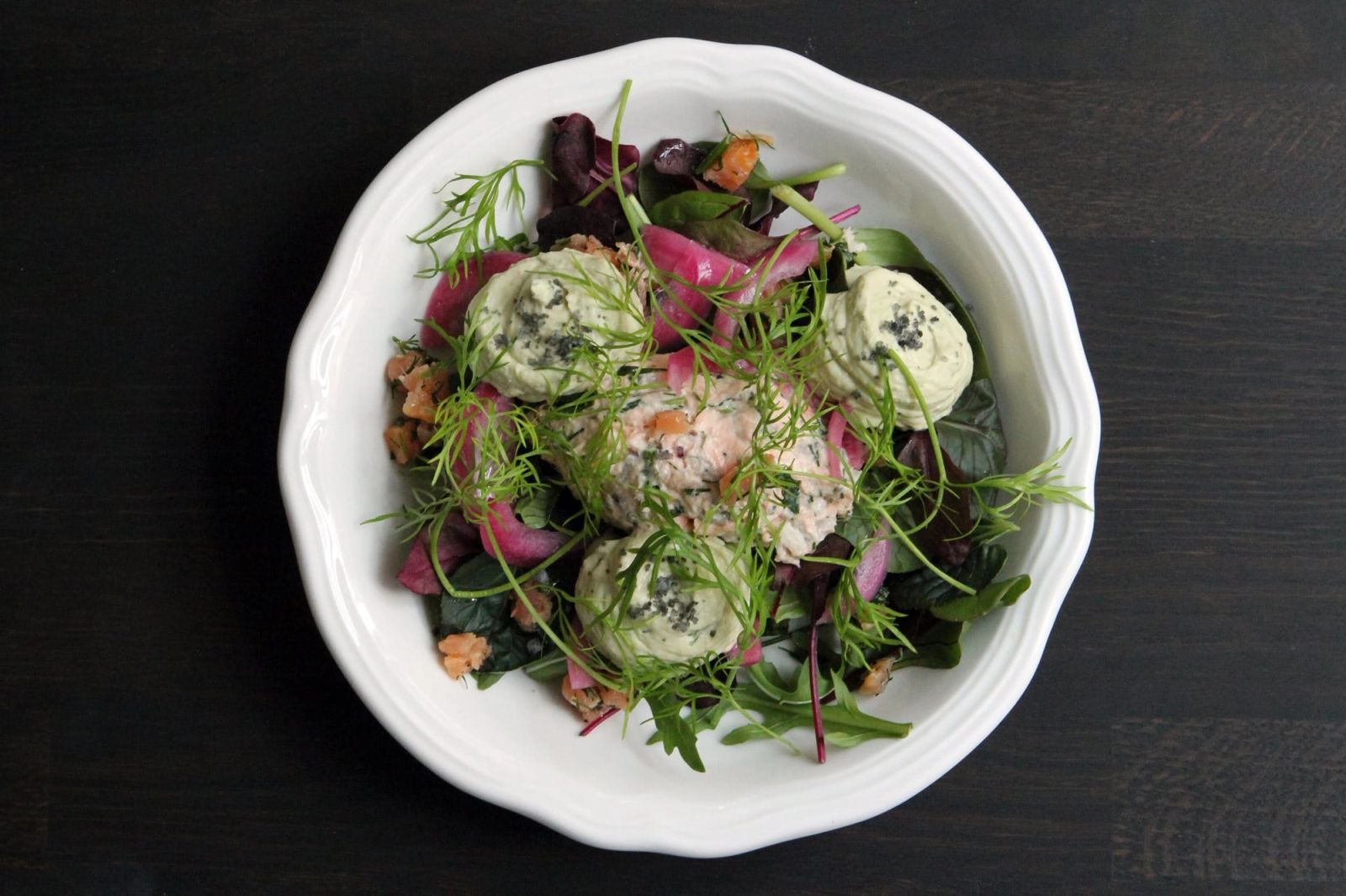 Food photography til sociale medier: elegant anrettet lakseret med cremefraiche, friske urter og farverige grøntsager på hvid tallerken