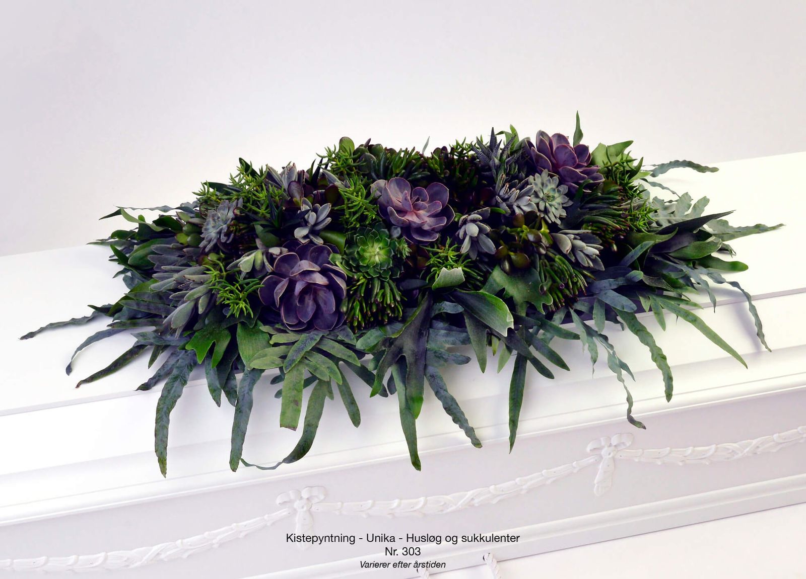 Styling of purple succulents and green foliage in elegant funeral floral arrangement