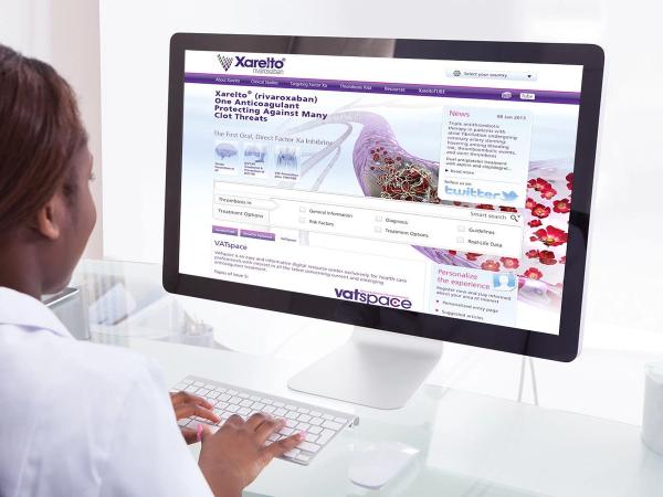 Healthcare professional in white coat at desktop computer showing Xarelto rivaroxaban anticoagulant website — digital medical detailing and UX/UI design for pharmaceutical industry