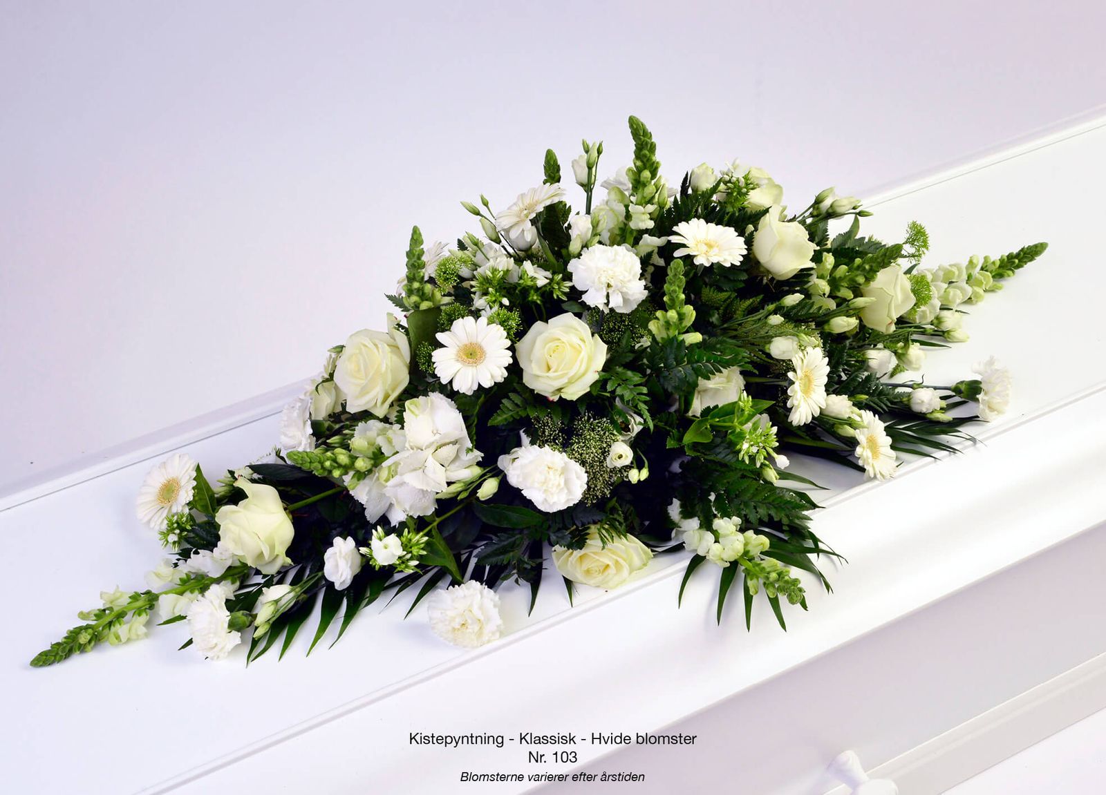 Dignified arrangement layout showcasing white roses, daisies and greenery for funeral flower catalogue
