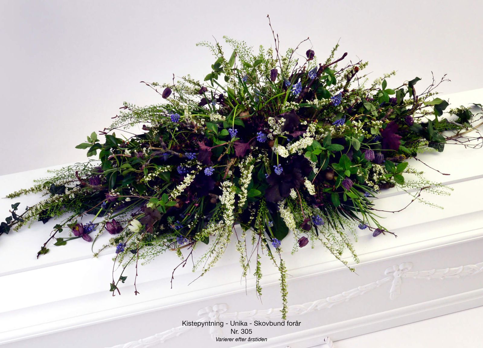 Still life photography direction for funeral service catalog featuring purple and white floral arrangement composition
