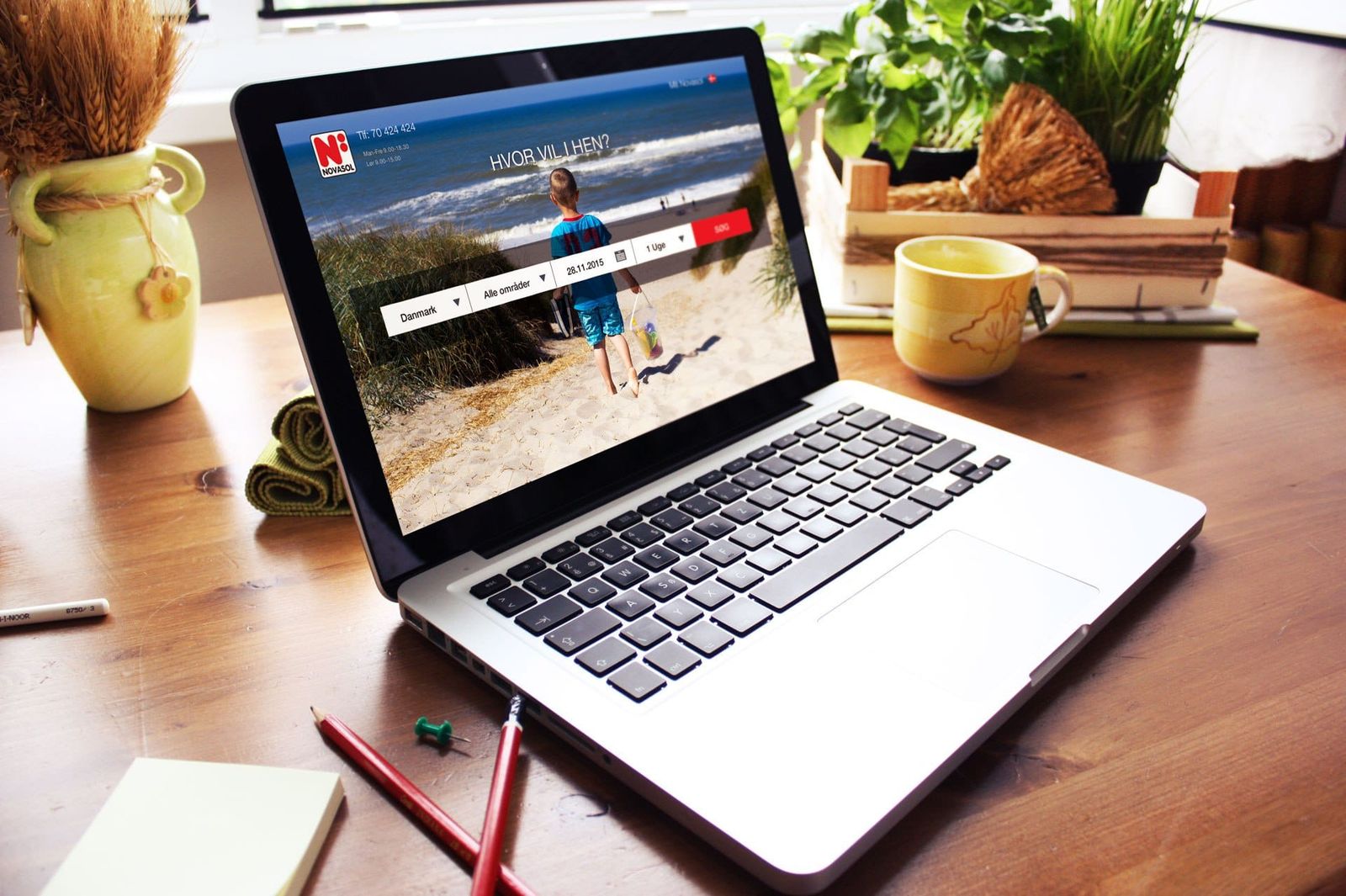 Responsive webdesign mockup på MacBook Pro viser inspirationsplatform med udvidet søgning efter rejsekategorier som ski og strand
